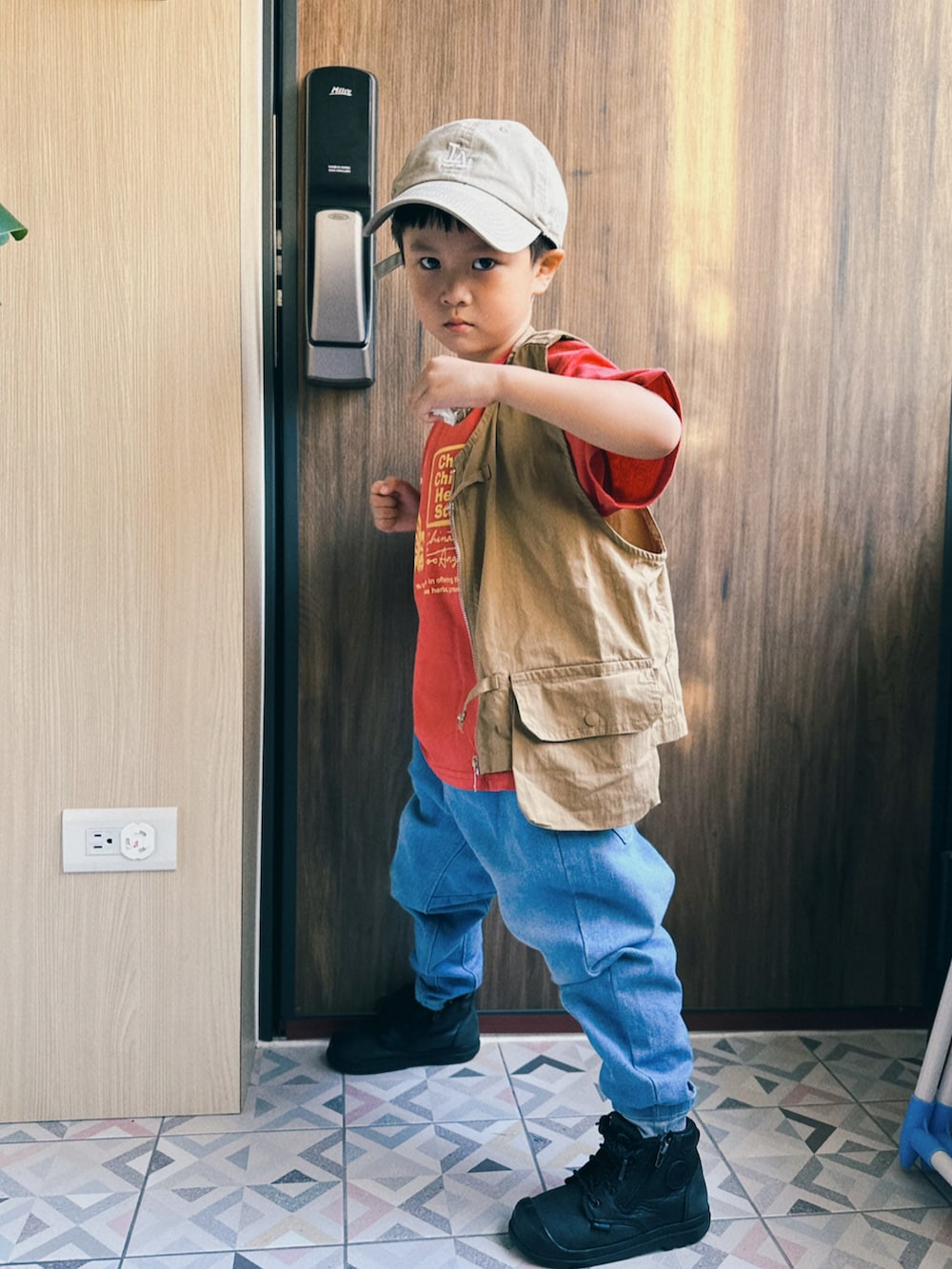 ブルー系のデニムパンツ、ブラック系のブーツ、レッド系のTシャツ/カットソーを着用したキッズの秋コーディネートの2枚目の写真