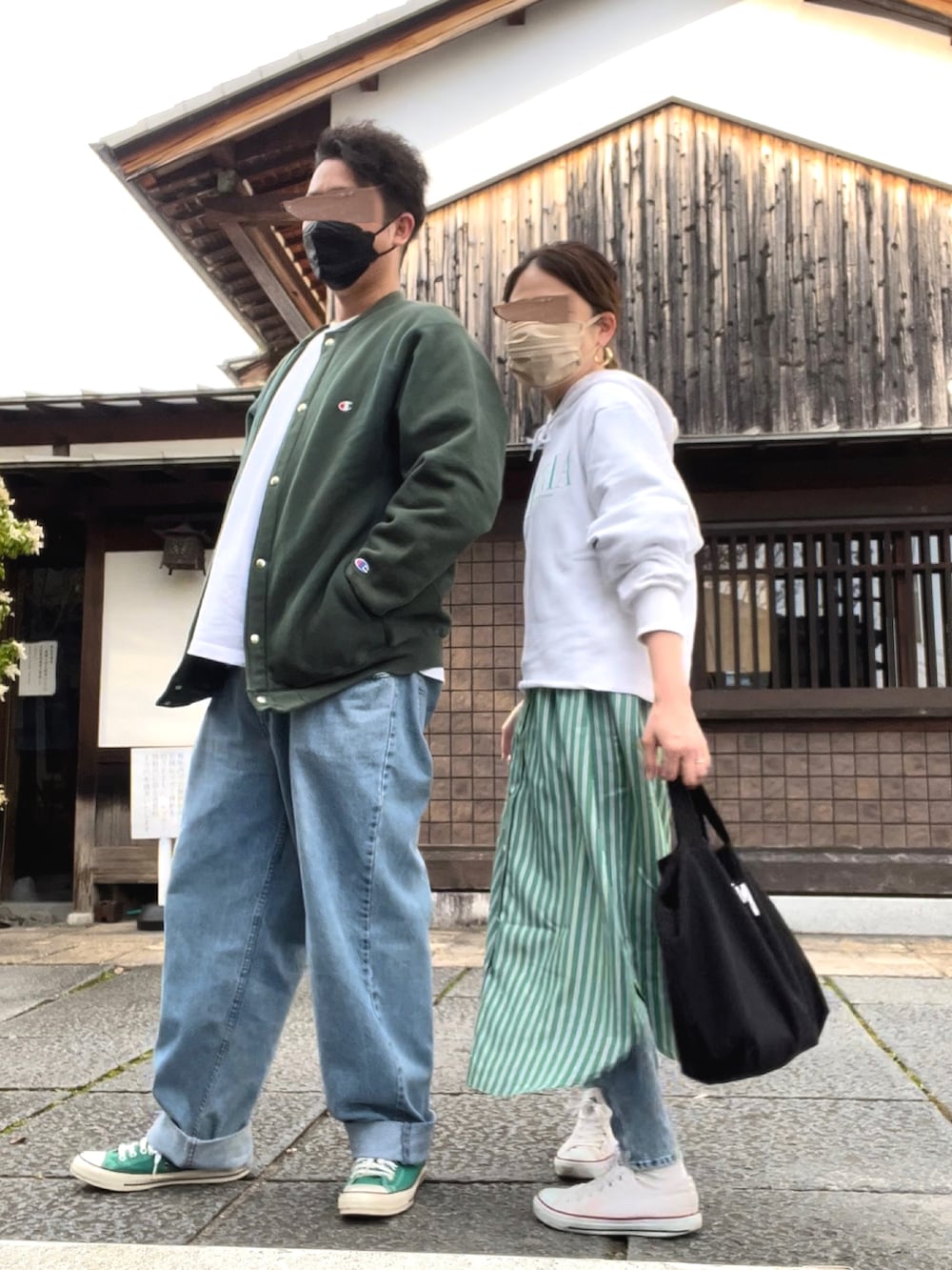ホワイト系のパーカー、グリーン系のシャツワンピース、ブラック系のトートバッグを着用したレディースの春コーディネートの2枚目の写真