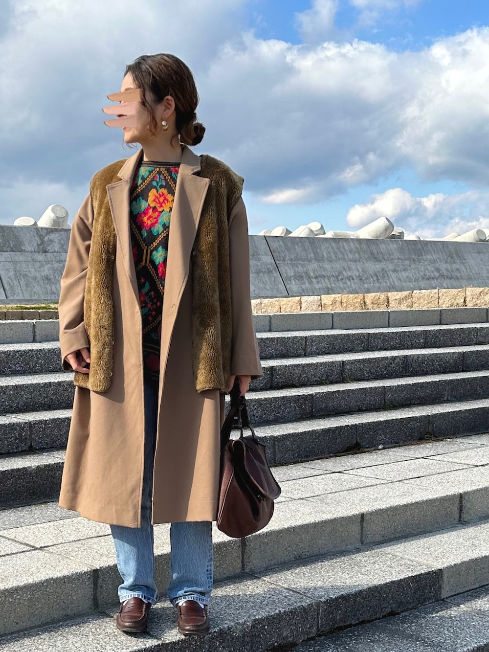 ブラック系のニット/セーター、イエロー系のその他アウター、ブラウン系のベストを着用したレディースの冬コーディネートの2枚目の写真