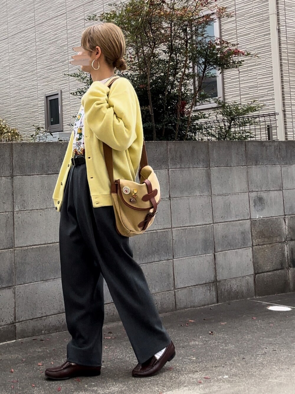 ホワイト系のスウェット、イエロー系のカーディガン/ボレロ、グレー系のスラックスを着用したレディースの冬コーディネートの2枚目の写真