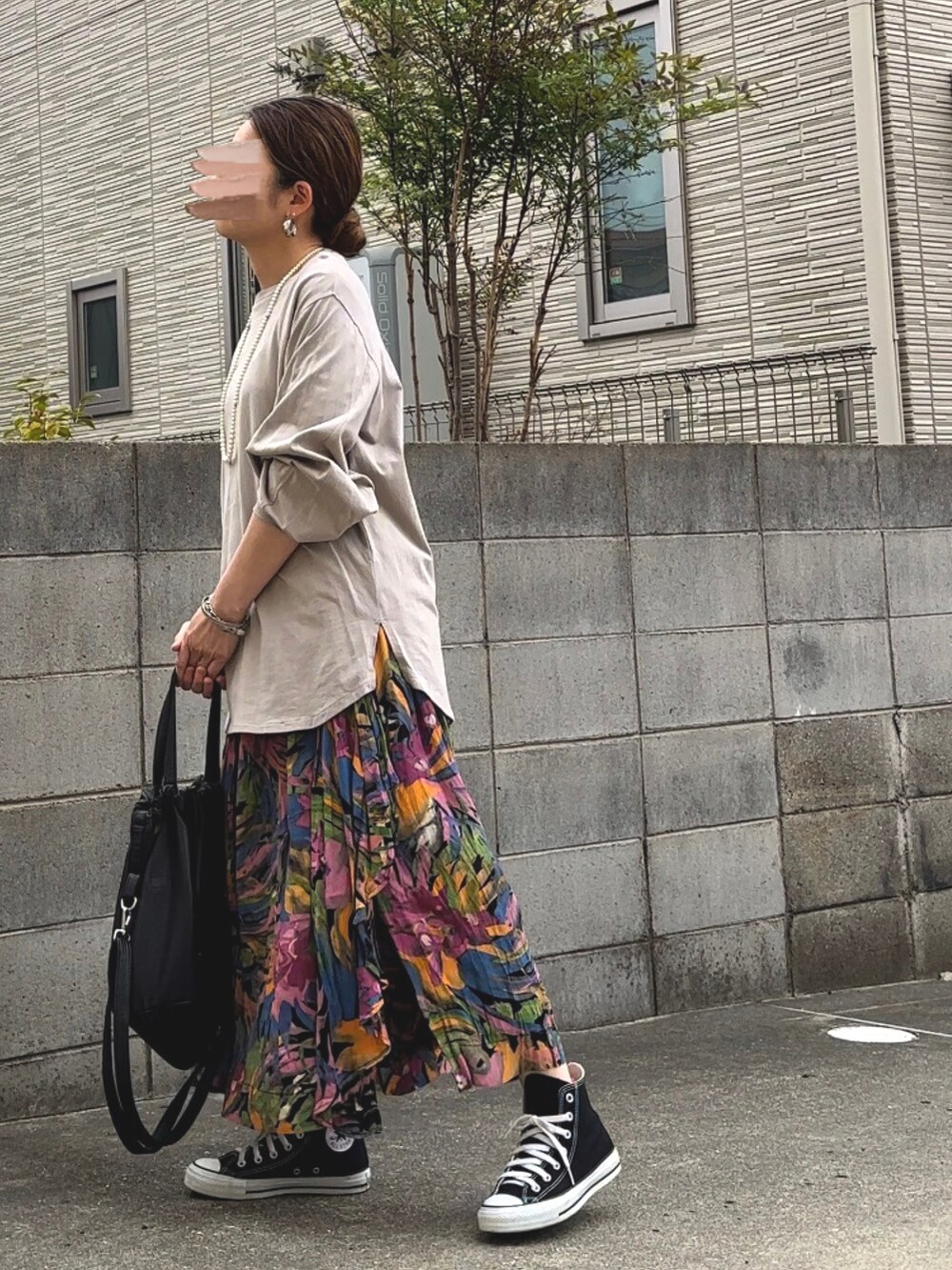 グリーン系のTシャツ/カットソー、ブラック系のショルダーバッグ、ブラック系のスニーカーを着用したレディースの春コーディネートの3枚目の写真