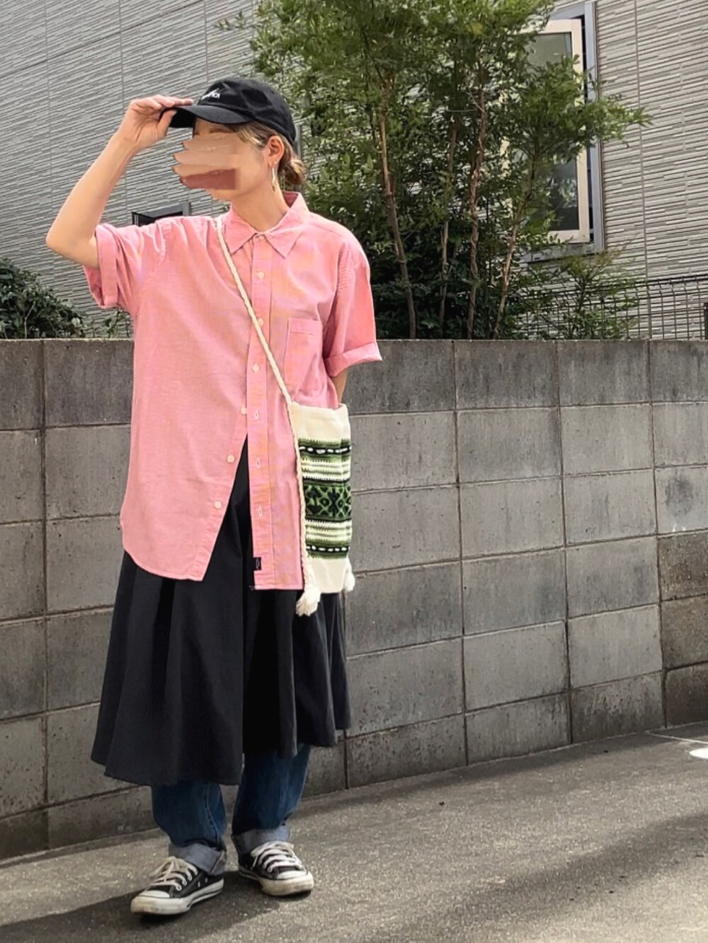 レッド系のシャツ/ブラウス、ブラック系のスカート、ブルー系のデニムパンツを着用したレディースの秋コーディネートの2枚目の写真