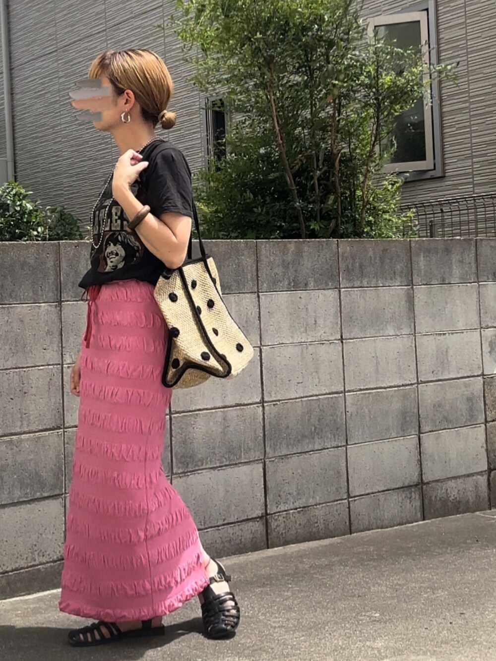 ブラック系のTシャツ/カットソー、ピンク系のスカート、ベージュ系のトートバッグを着用したレディースの夏コーディネートの3枚目の写真