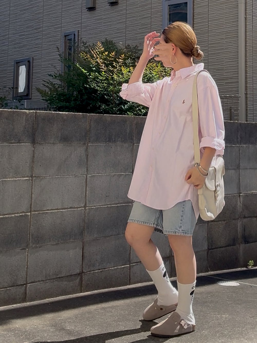 ベージュ系のスリッポン、ピンク系のシャツ/ブラウス、ブルー系のデニムパンツを着用したレディースの秋コーディネートの2枚目の写真