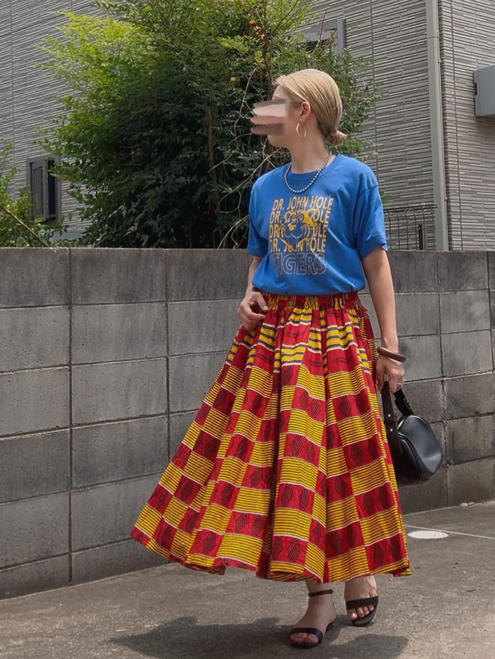 ブルー系のTシャツ/カットソー、レッド系のスカート、ブラック系のハンドバッグを着用したレディースの夏コーディネートの2枚目の写真