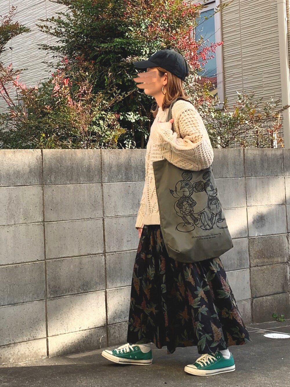 ホワイト系のニット/セーター、ブラック系のスカート、グリーン系のトートバッグを着用したレディースの冬コーディネートの2枚目の写真