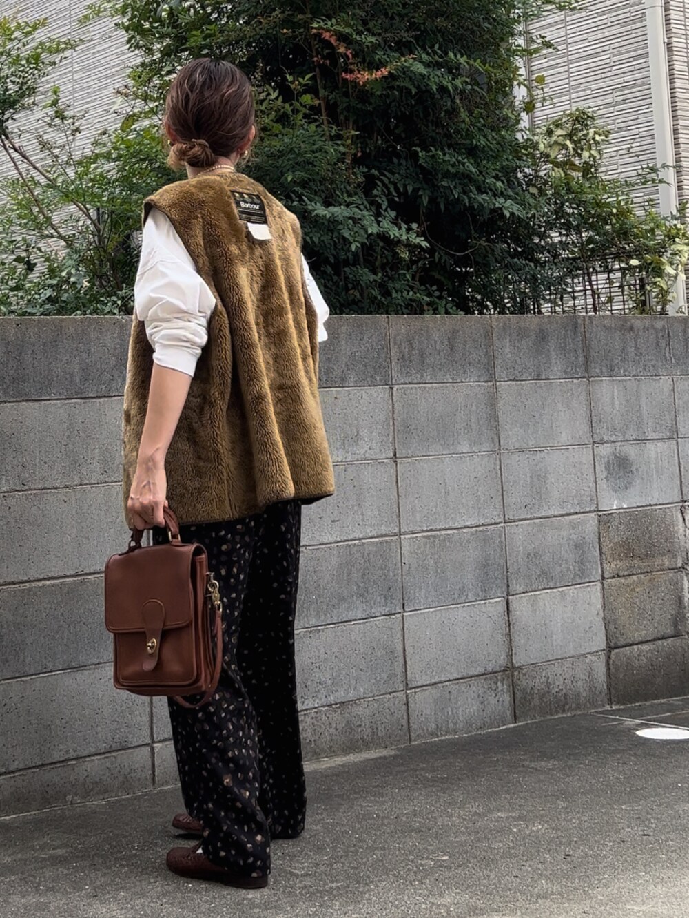 ブラウン系のベスト、ホワイト系のTシャツ/カットソー、ブラック系のその他パンツを着用したレディースの秋コーディネートの3枚目の写真