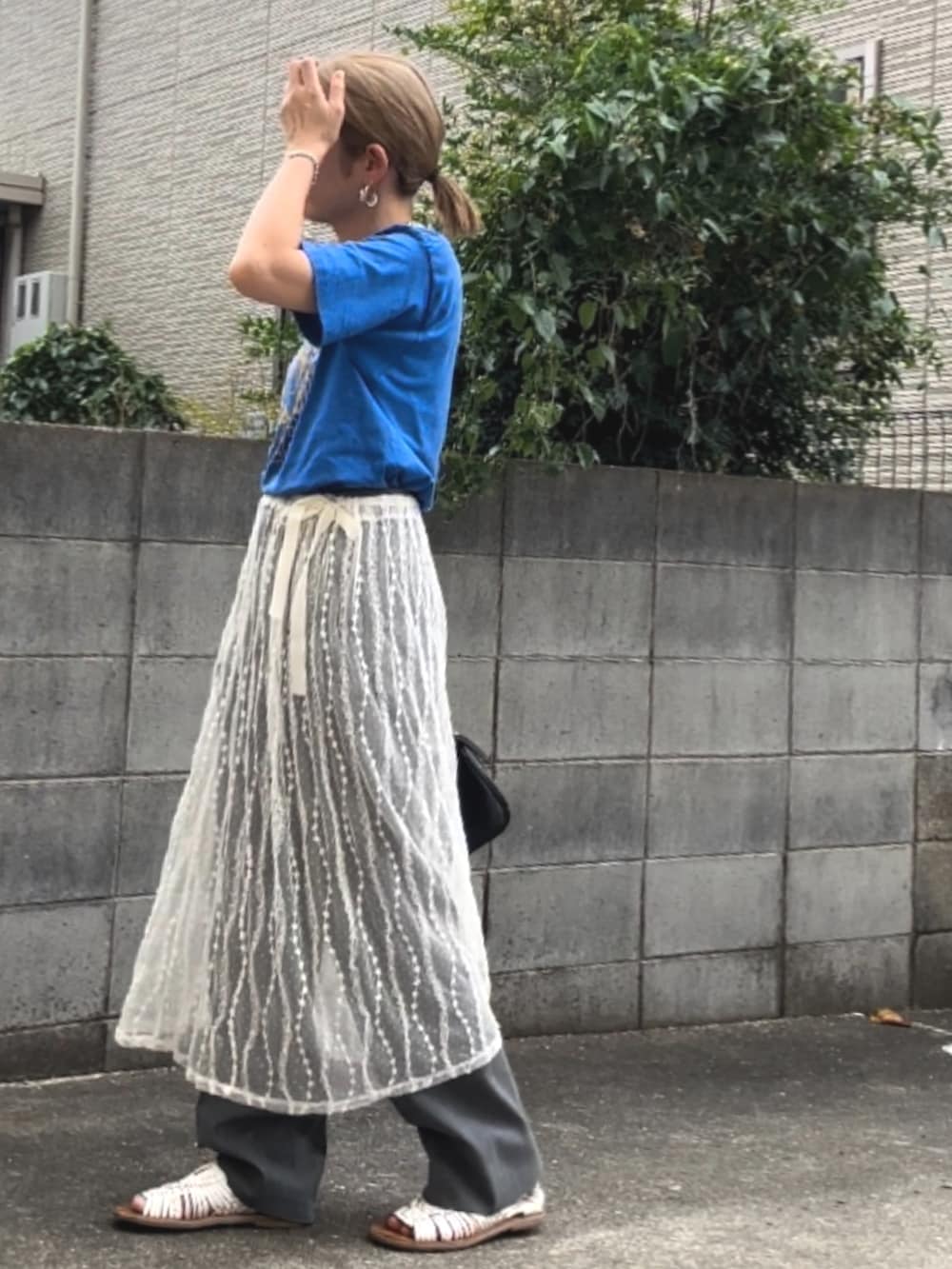 ブルー系のTシャツ/カットソー、ホワイト系のスカート、グレー系のスラックスを着用したレディースの夏コーディネートの3枚目の写真