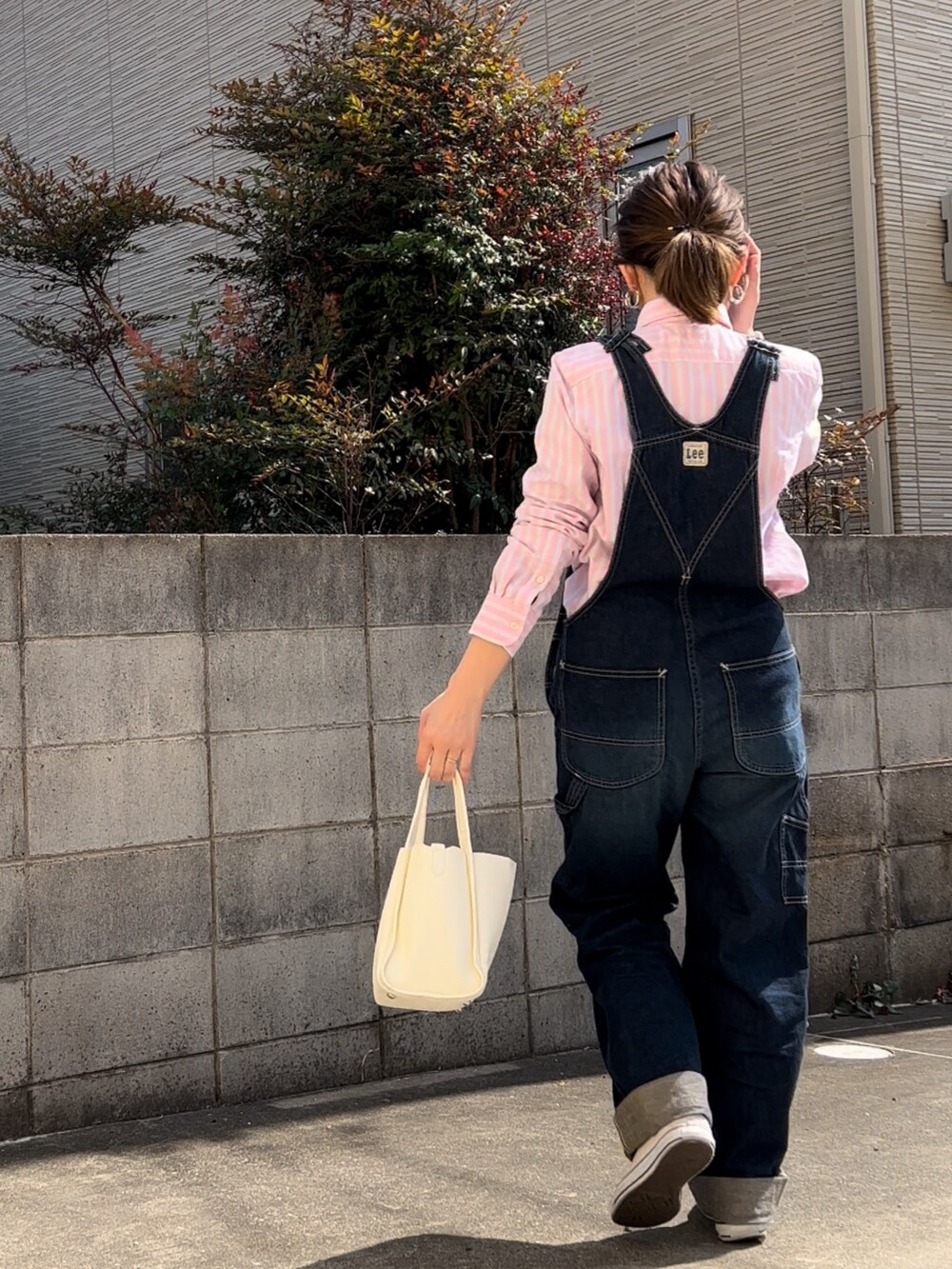 ブルー系のサロペット/オーバーオール、ピンク系のシャツ/ブラウス、ホワイト系のトートバッグを着用したレディースの春コーディネートの2枚目の写真