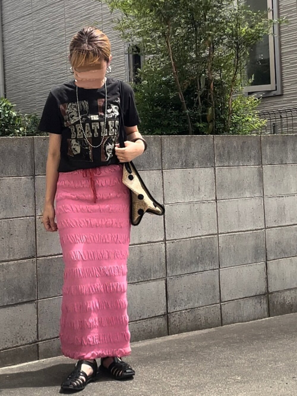 ブラック系のTシャツ/カットソー、ピンク系のスカート、ベージュ系のトートバッグを着用したレディースの夏コーディネートの2枚目の写真
