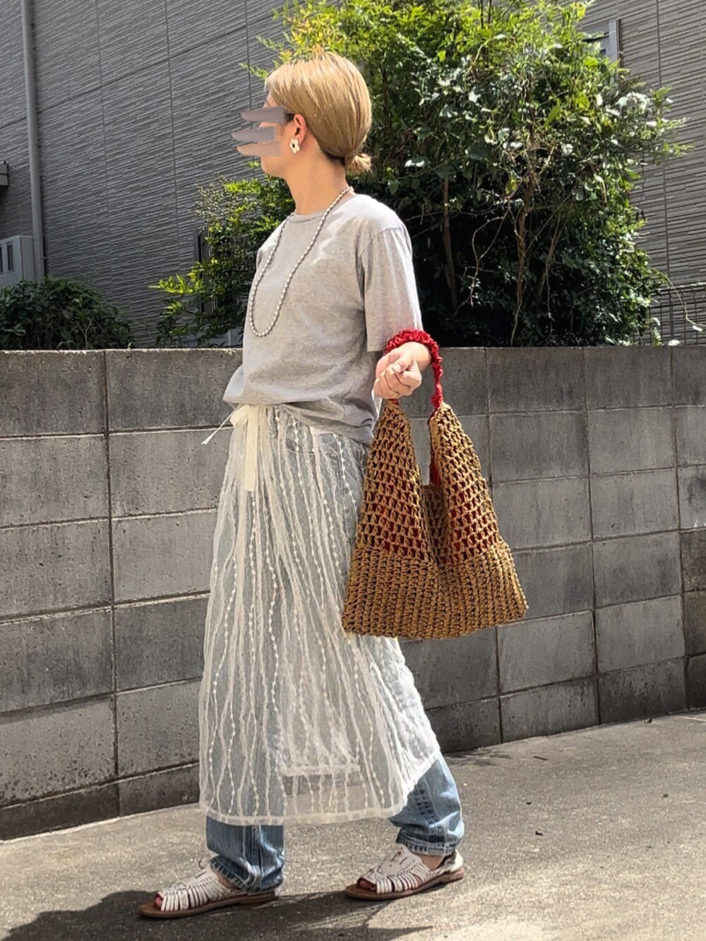 ホワイト系のスカート、ブルー系のデニムパンツ、ホワイト系のサンダルを着用したレディースの夏コーディネートの2枚目の写真