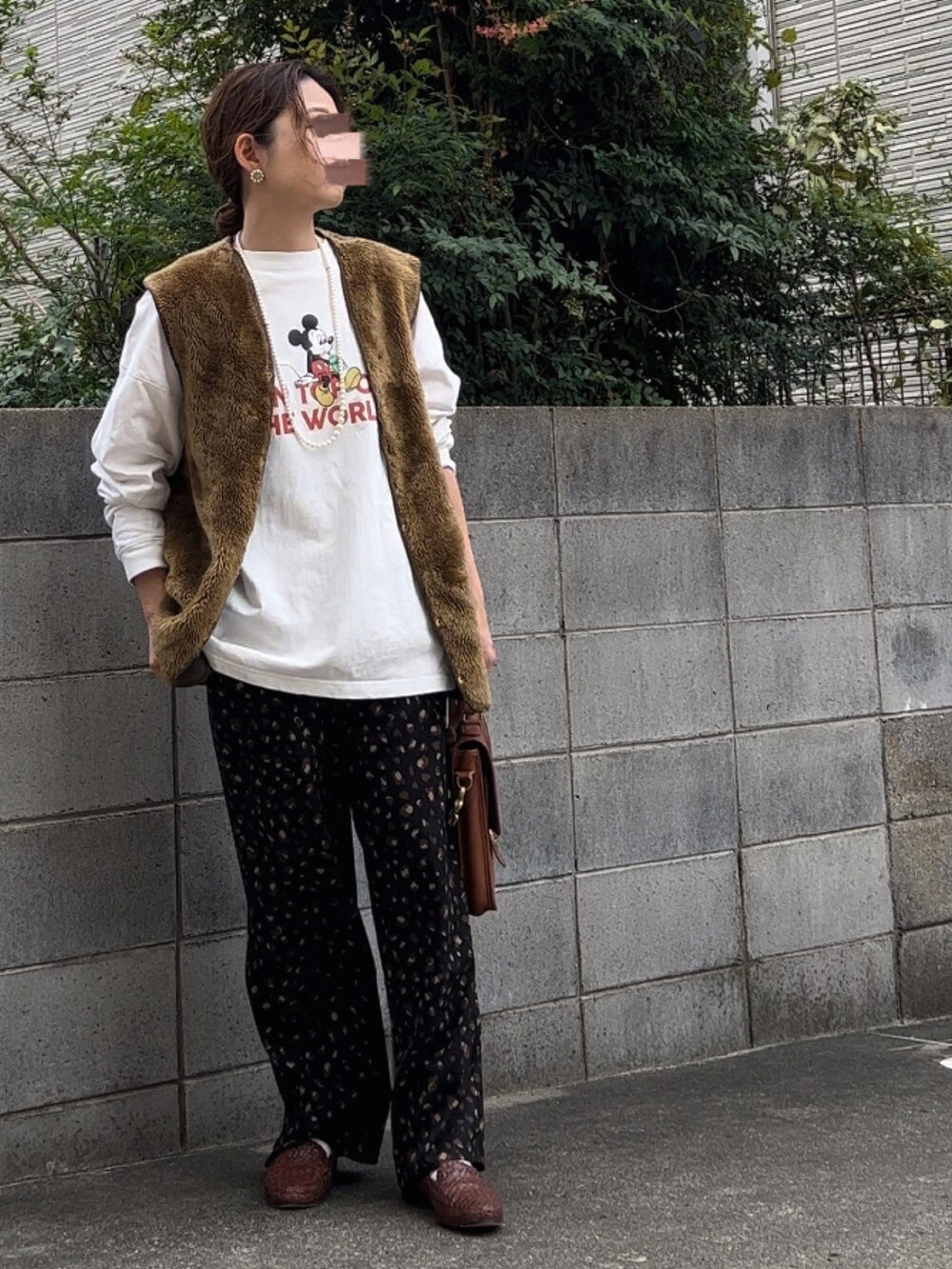 ブラウン系のベスト、ホワイト系のTシャツ/カットソー、ブラック系のその他パンツを着用したレディースの秋コーディネートの2枚目の写真