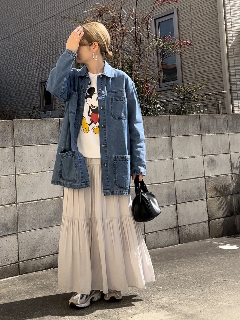 ブルー系のカバーオール、ホワイト系のスウェット、グレー系のスカートを着用したレディースの春コーディネートの3枚目の写真