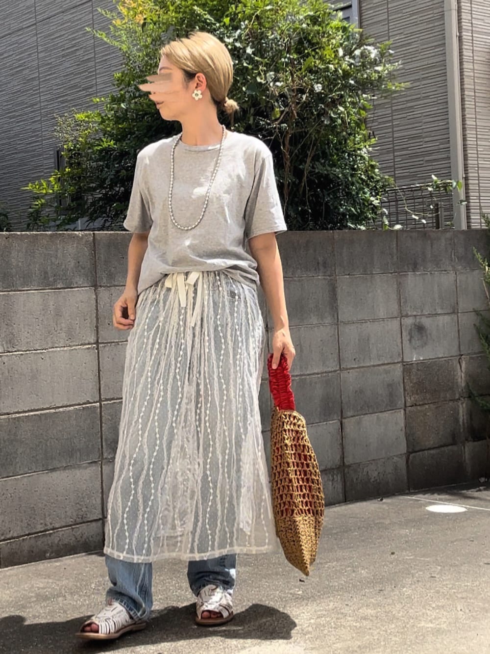 ホワイト系のスカート、ブルー系のデニムパンツ、ホワイト系のサンダルを着用したレディースの夏コーディネートの3枚目の写真