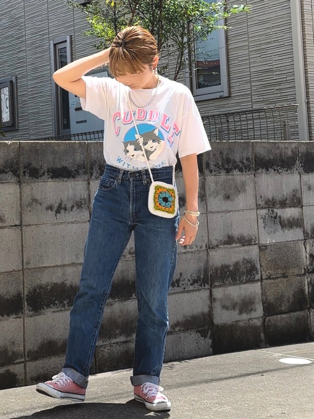 ホワイト系のTシャツ/カットソー、ブルー系のデニムパンツ、ピンク系のスニーカーを着用したレディースの春コーディネートの2枚目の写真