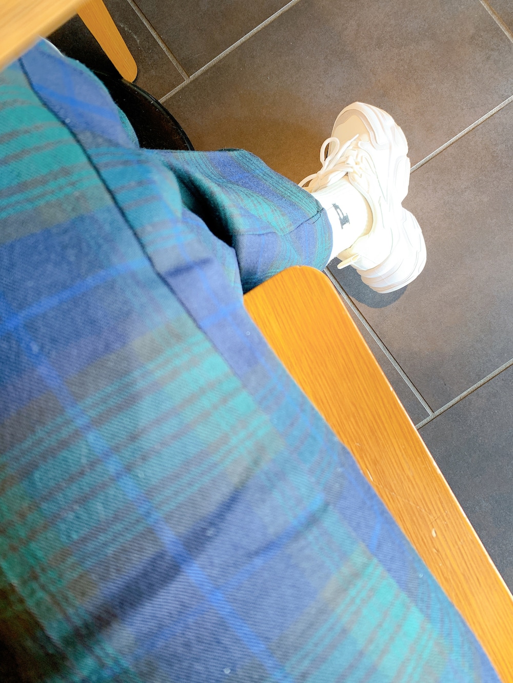 グリーン系のスラックス、ブラック系のスタジャン、ホワイト系のスウェットを着用したレディースの冬コーディネートの3枚目の写真