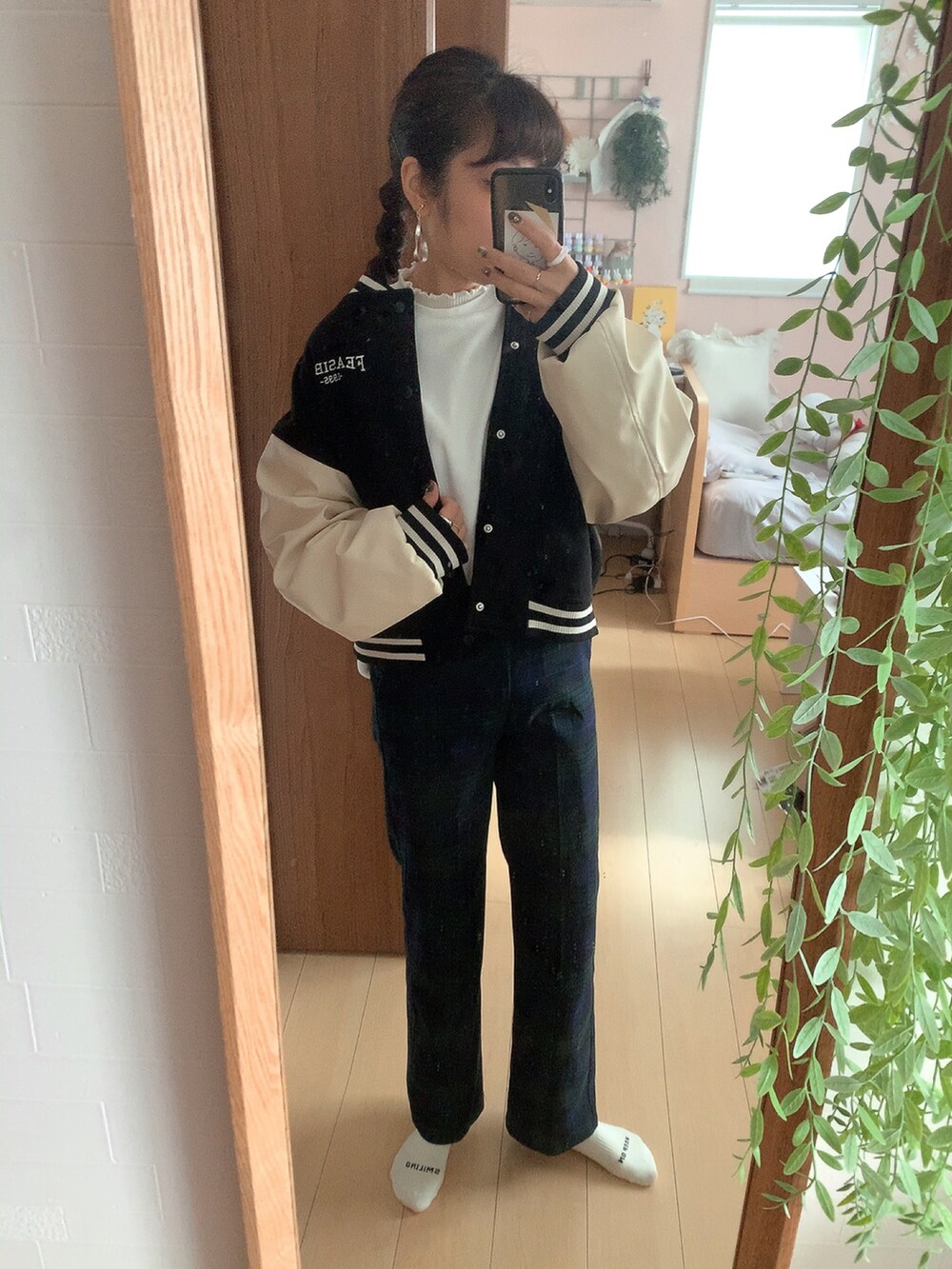 グリーン系のスラックス、ブラック系のスタジャン、ホワイト系のスウェットを着用したレディースの冬コーディネートの2枚目の写真