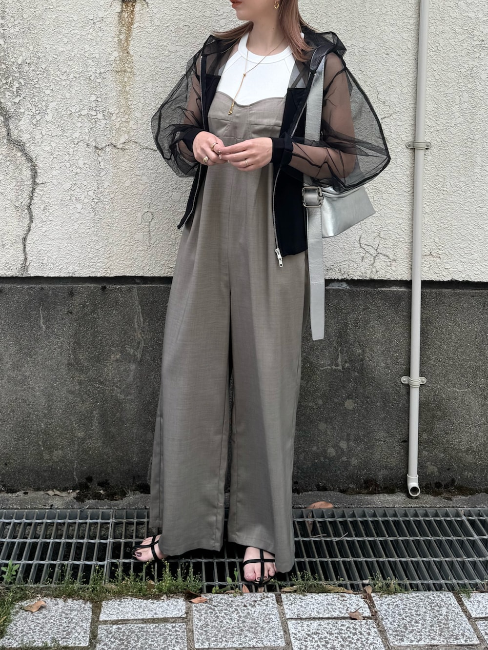 ブラック系のパーカー、グレー系のサロペット/オーバーオール、ブラック系のサンダルを着用したレディースの夏コーディネートの3枚目の写真