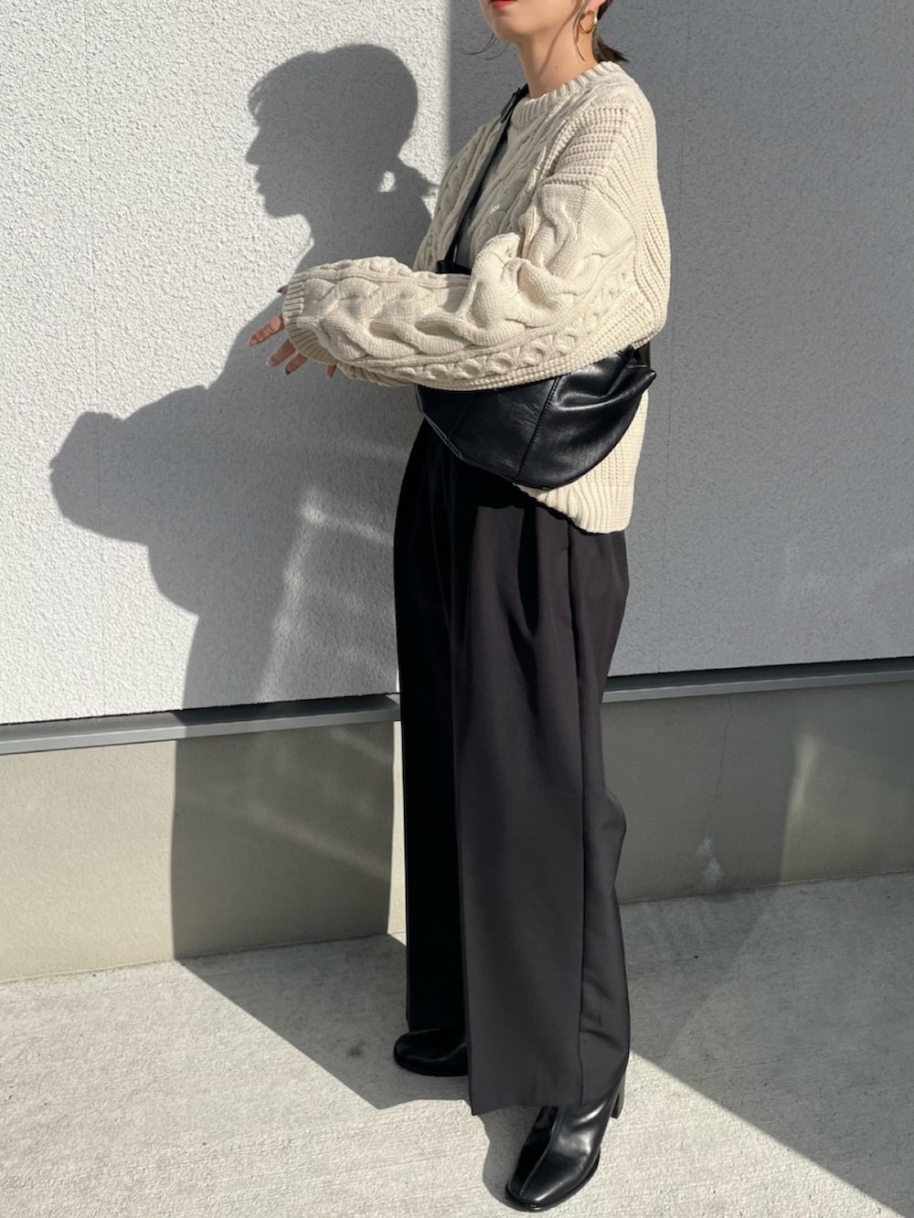 ホワイト系のニット/セーター、ブラック系のブーツ、ブラック系のその他パンツを着用したレディースの秋コーディネートの3枚目の写真