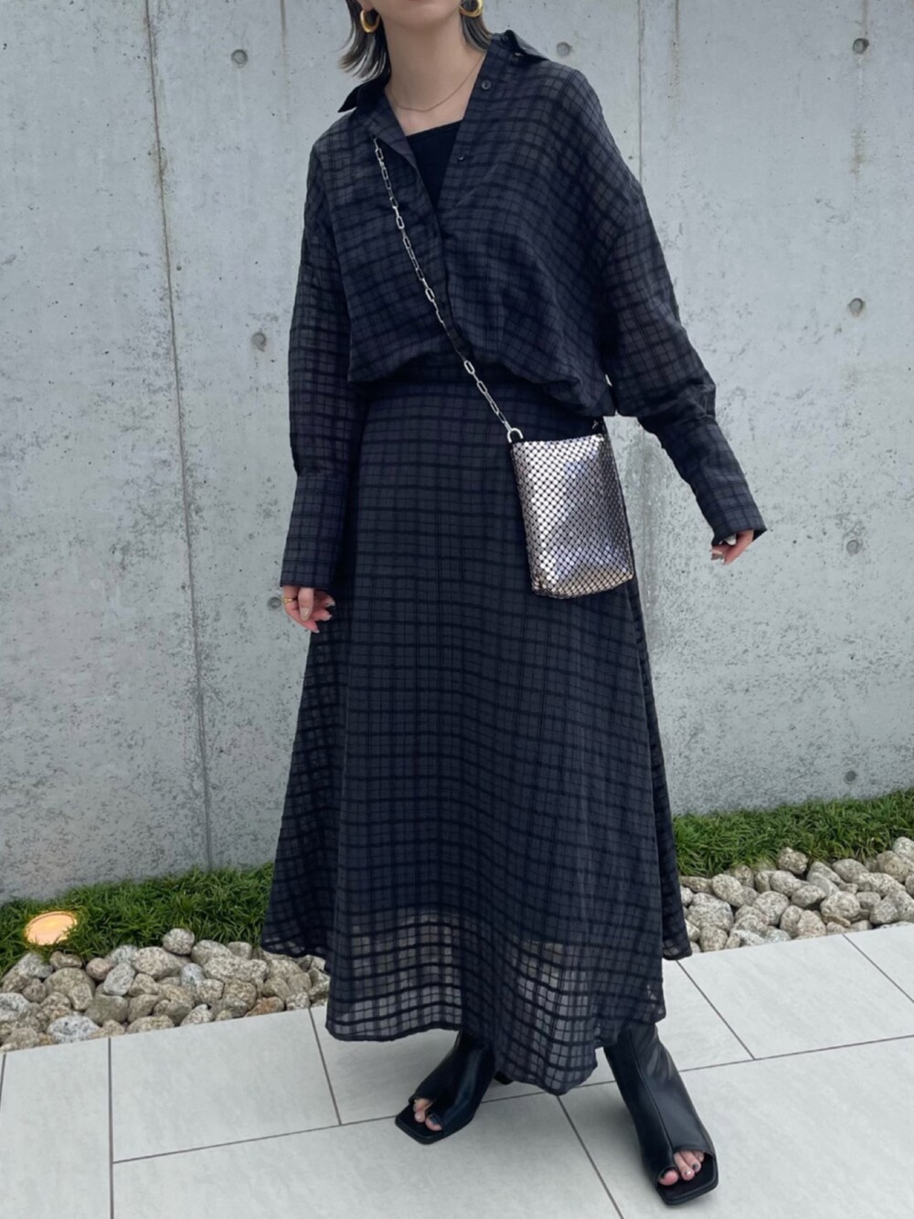 グレー系のシャツ/ブラウス、グレー系のスカート、シルバー系のショルダーバッグを着用したレディースの夏コーディネートの3枚目の写真