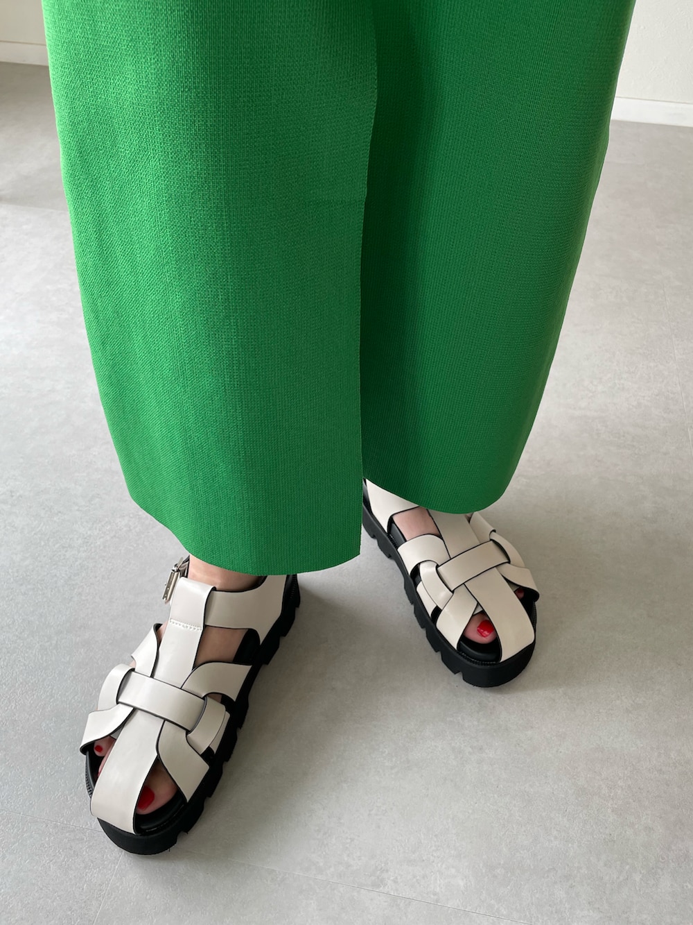 ホワイト系のサンダル、グリーン系のスカート、グレー系のスウェットを着用したレディースの春コーディネートの3枚目の写真