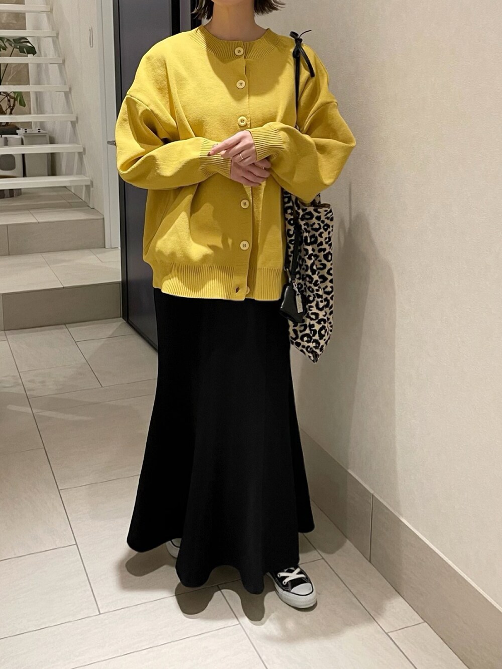 イエロー系のニット/セーター、その他のトートバッグ、ブラック系のスカートを着用したレディースの冬コーディネートの4枚目の写真