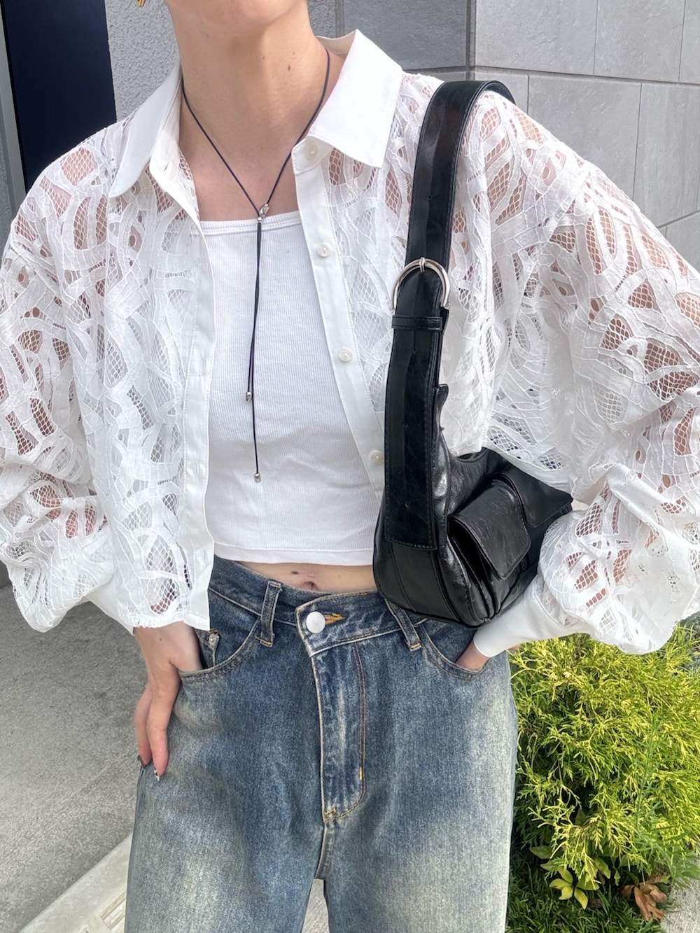 ブルー系のデニムパンツ、ブラック系のショルダーバッグ、ブラック系のスニーカーを着用したレディースの夏コーディネートの4枚目の写真