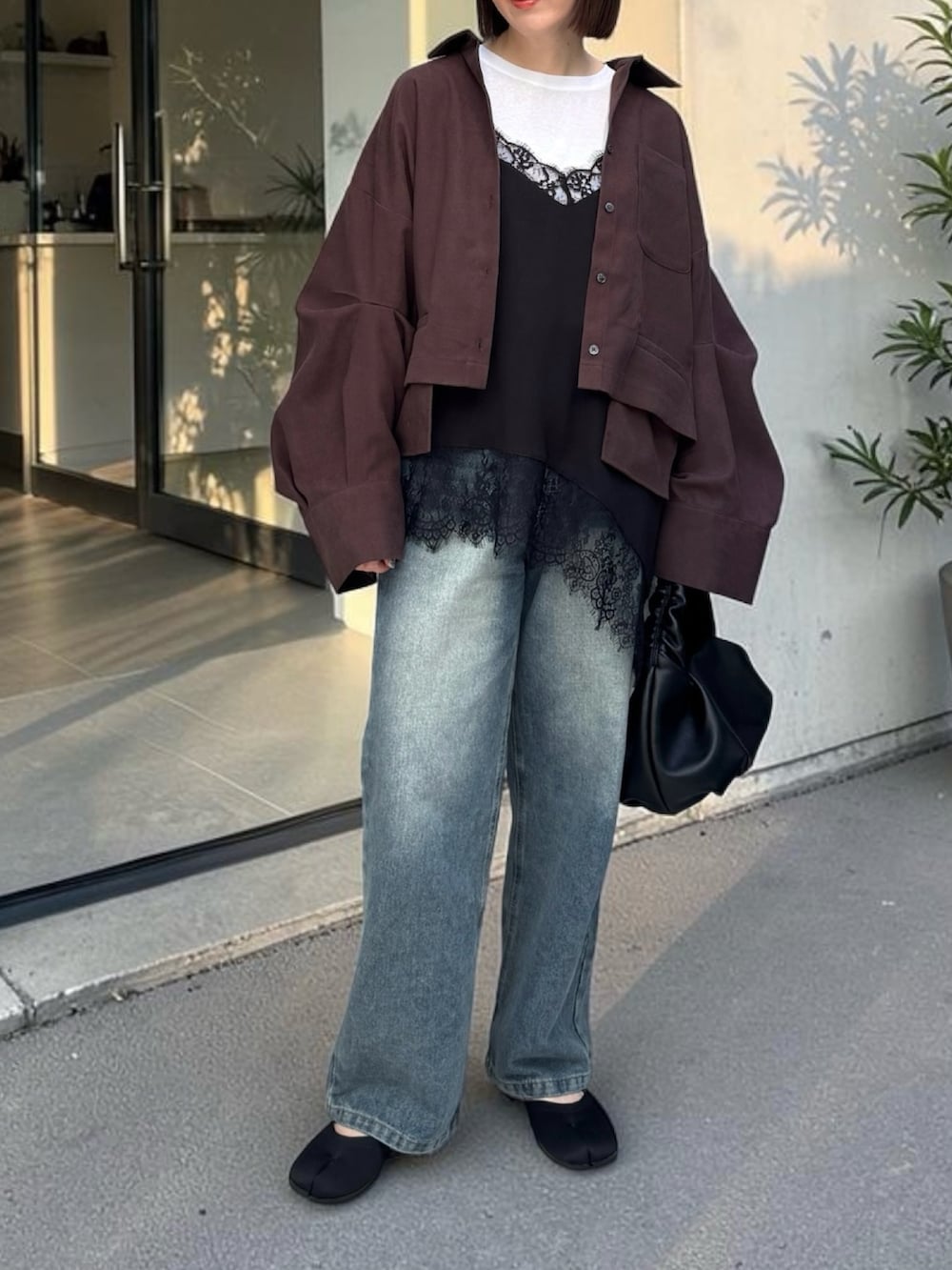 ブラウン系のシャツ/ブラウス、ブルー系のデニムパンツ、ブラック系のショルダーバッグを着用したレディースの春コーディネートの2枚目の写真