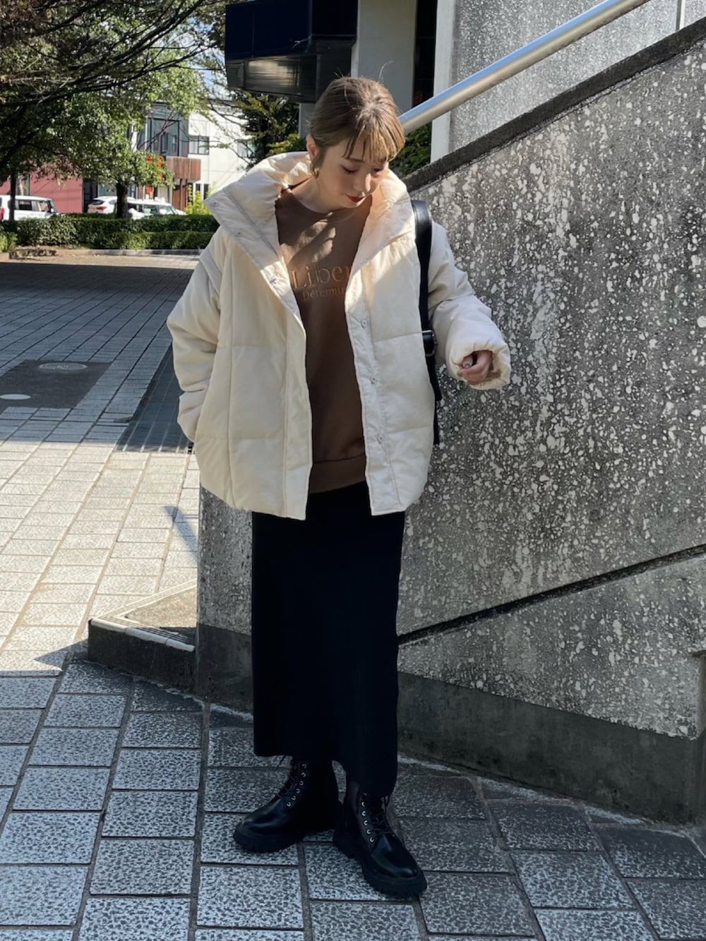 ホワイト系のその他アウター、ブラック系のスカート、ブラック系のブーツを着用したレディースの秋コーディネートの2枚目の写真