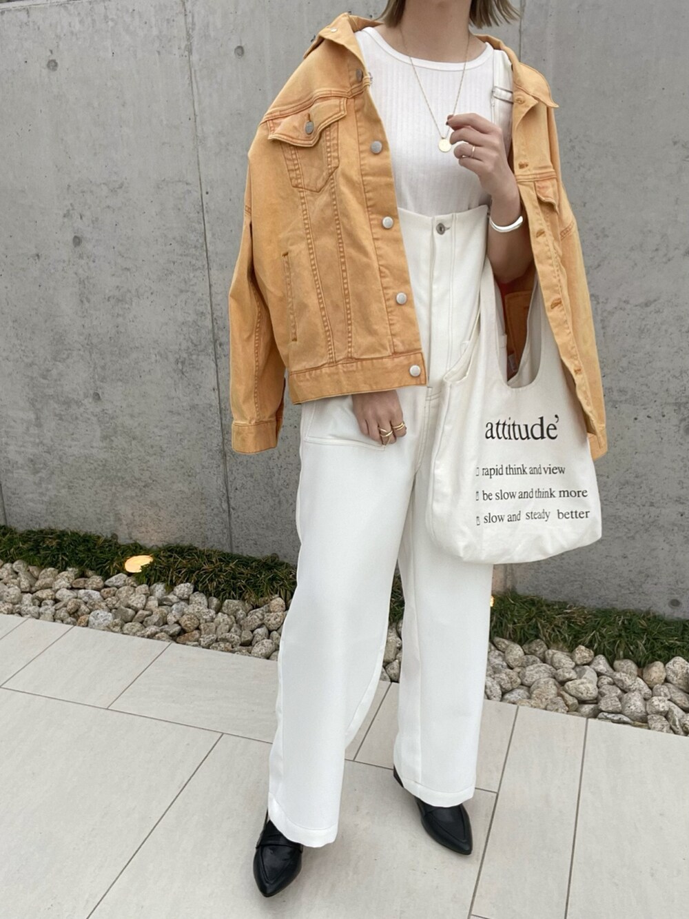 オレンジ系のデニムジャケット、ブラック系のローファー、ホワイト系のサロペット/オーバーオールを着用したレディースの春コーディネートの4枚目の写真