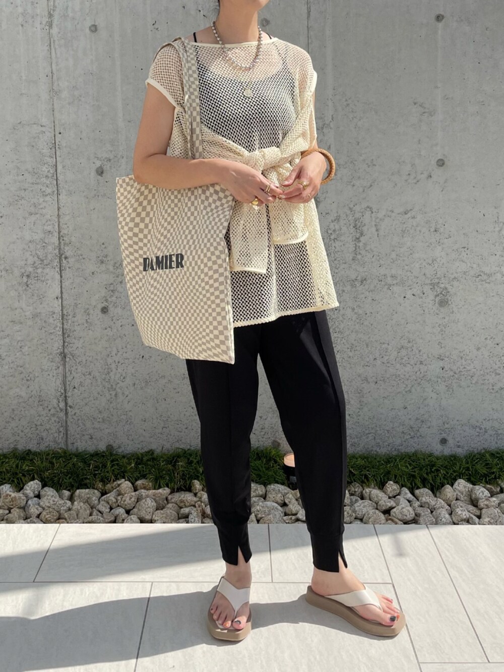 ブラック系のその他パンツ、ホワイト系のTシャツ/カットソー、ホワイト系のサンダルを着用したレディースの夏コーディネートの3枚目の写真
