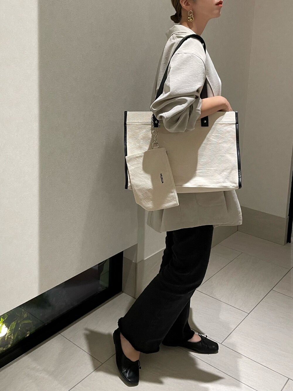 ホワイト系のトートバッグ、グレー系のテーラードジャケット、オレンジ系のTシャツ/カットソーを着用したレディースの秋コーディネートの2枚目の写真