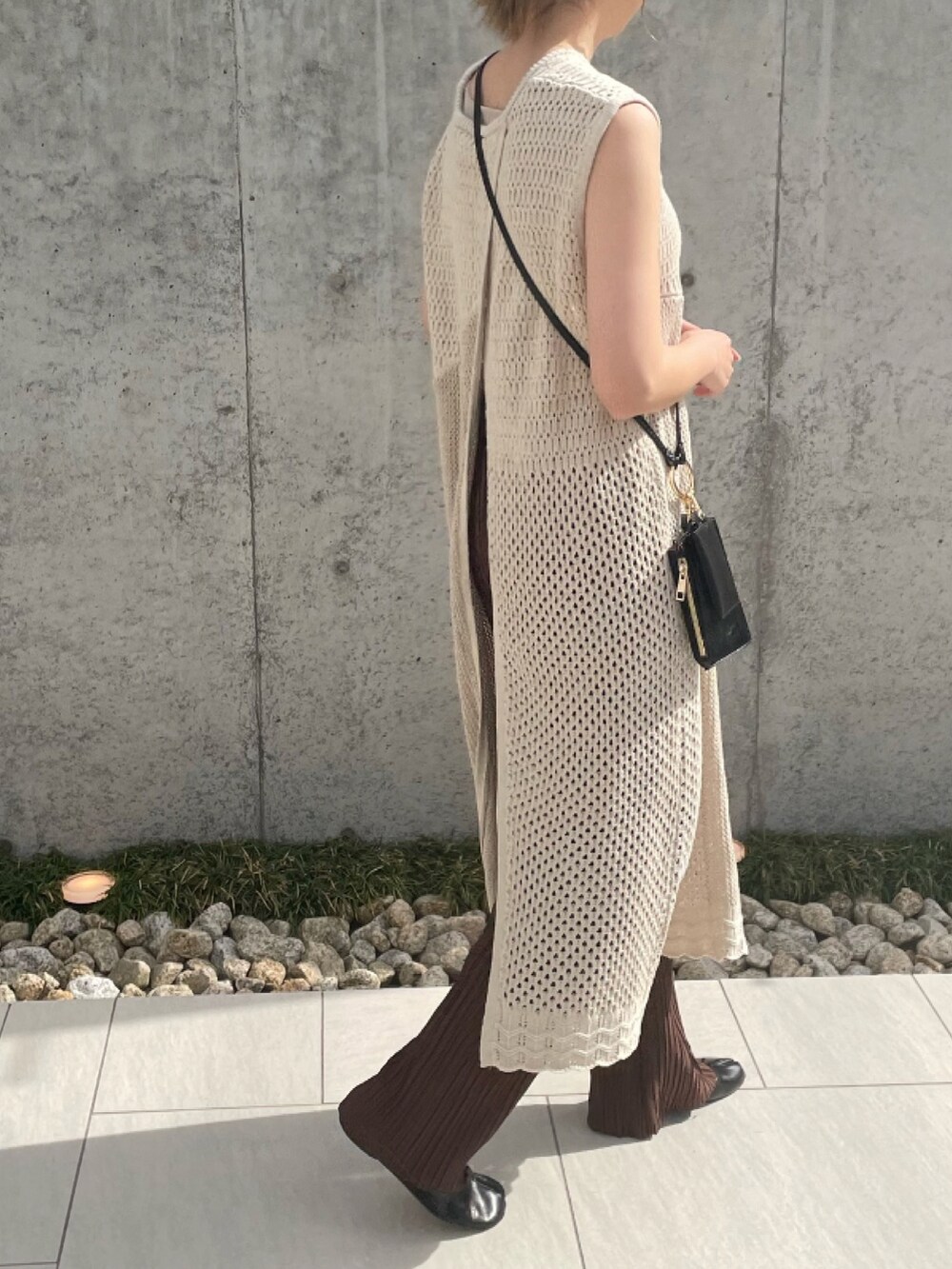 ホワイト系のニット/セーター、ブラック系のショルダーバッグ、ブラック系のパンプスを着用したレディースの春コーディネートの4枚目の写真