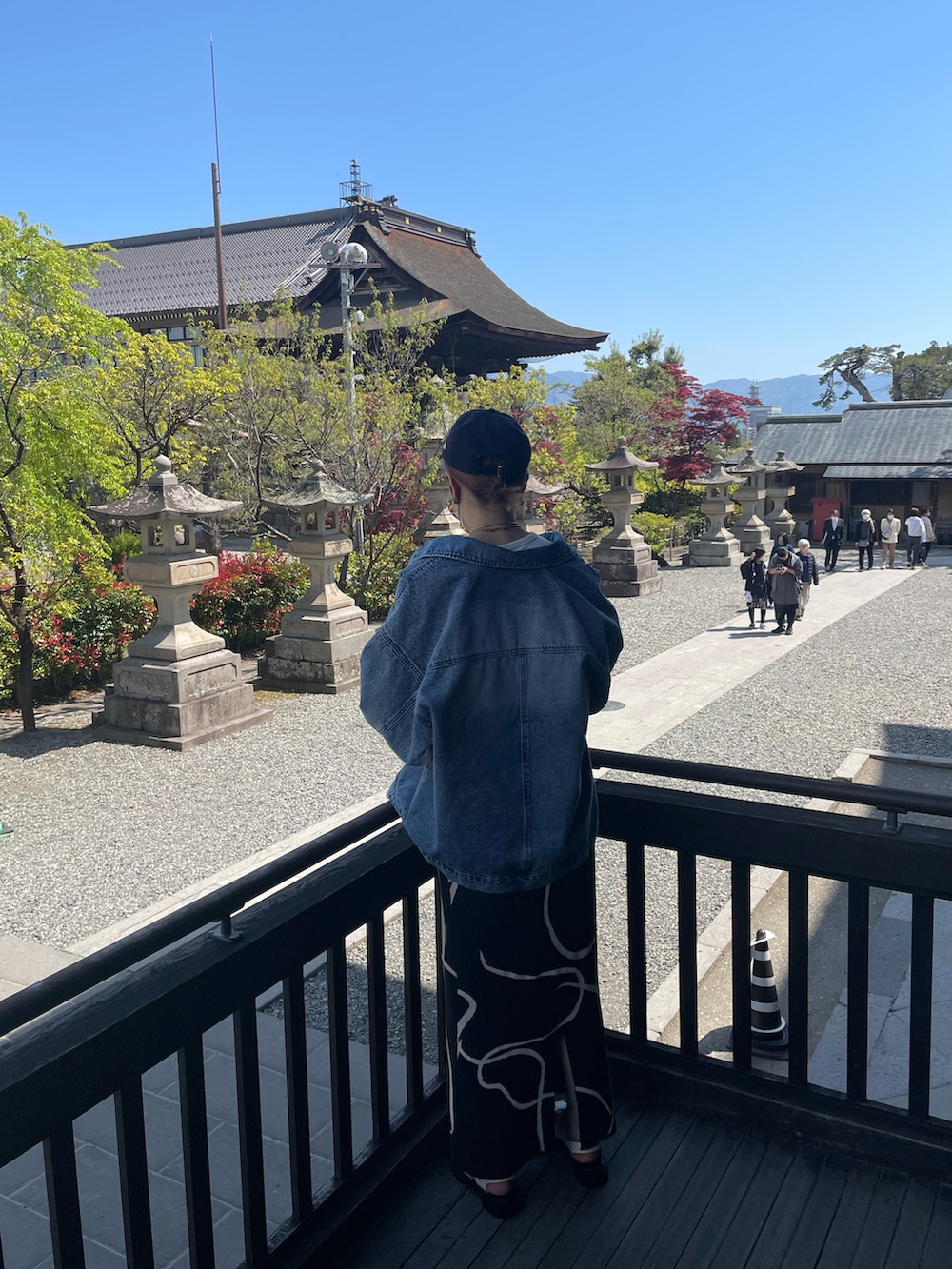 ホワイト系のTシャツ/カットソー、グレー系のスカート、ホワイト系のサンダルを着用したレディースの春コーディネートの3枚目の写真