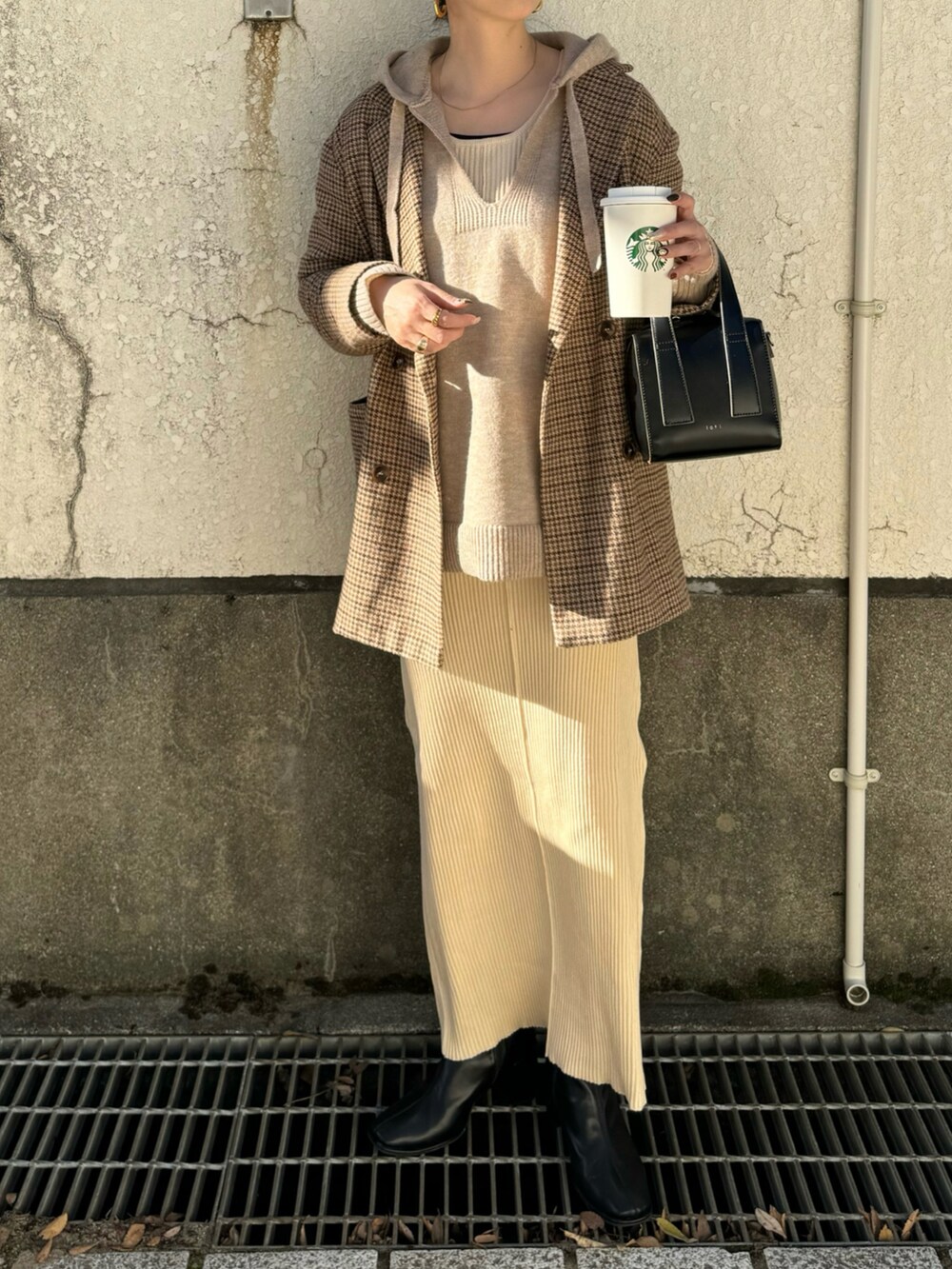 ホワイト系のワンピース、ブラック系のボストンバッグ、ベージュ系のニット/セーターを着用したレディースの秋コーディネートの4枚目の写真