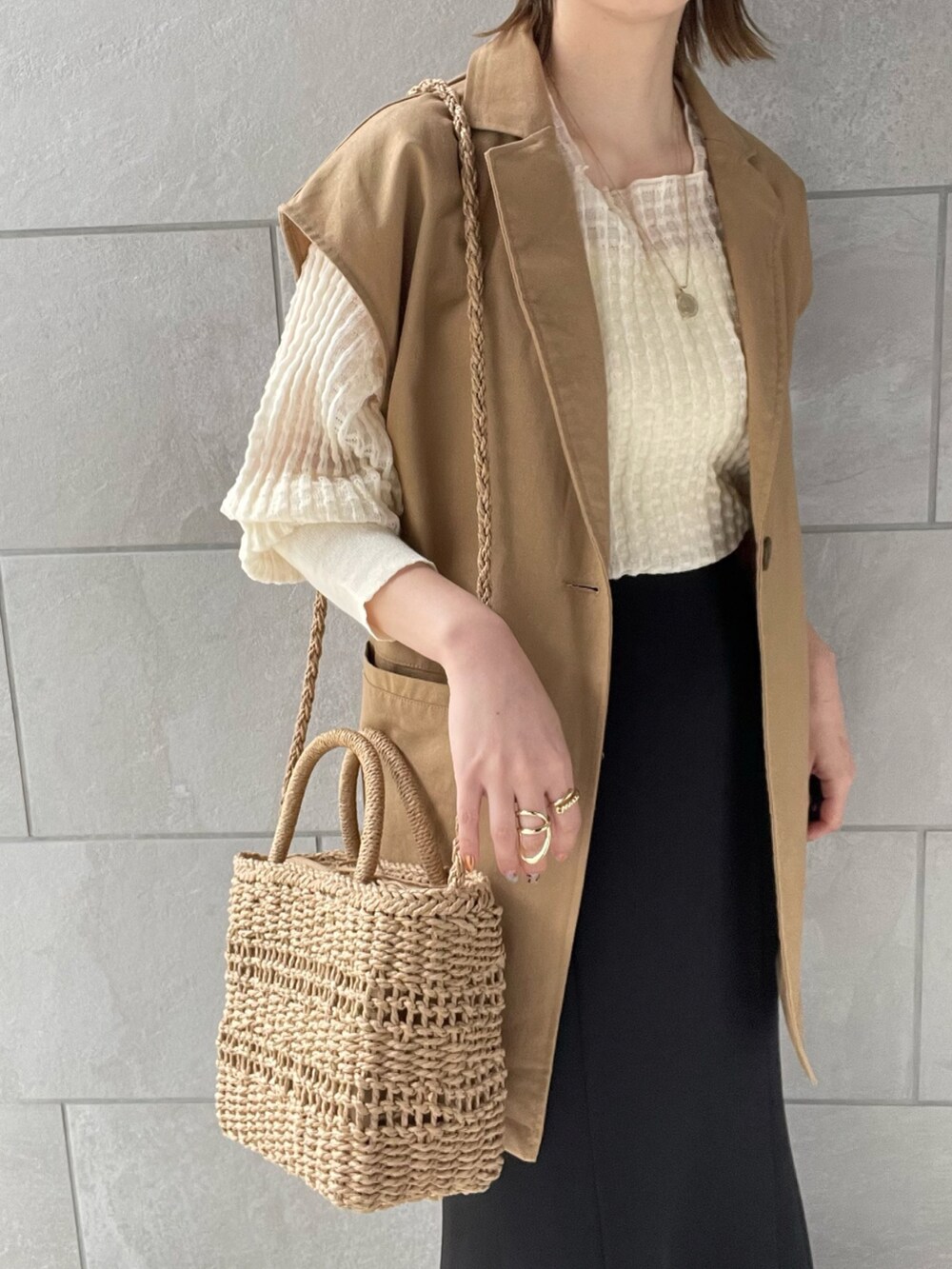 イエロー系のベスト、ホワイト系のニット/セーター、ホワイト系のパンプスを着用したレディースの春コーディネートの4枚目の写真