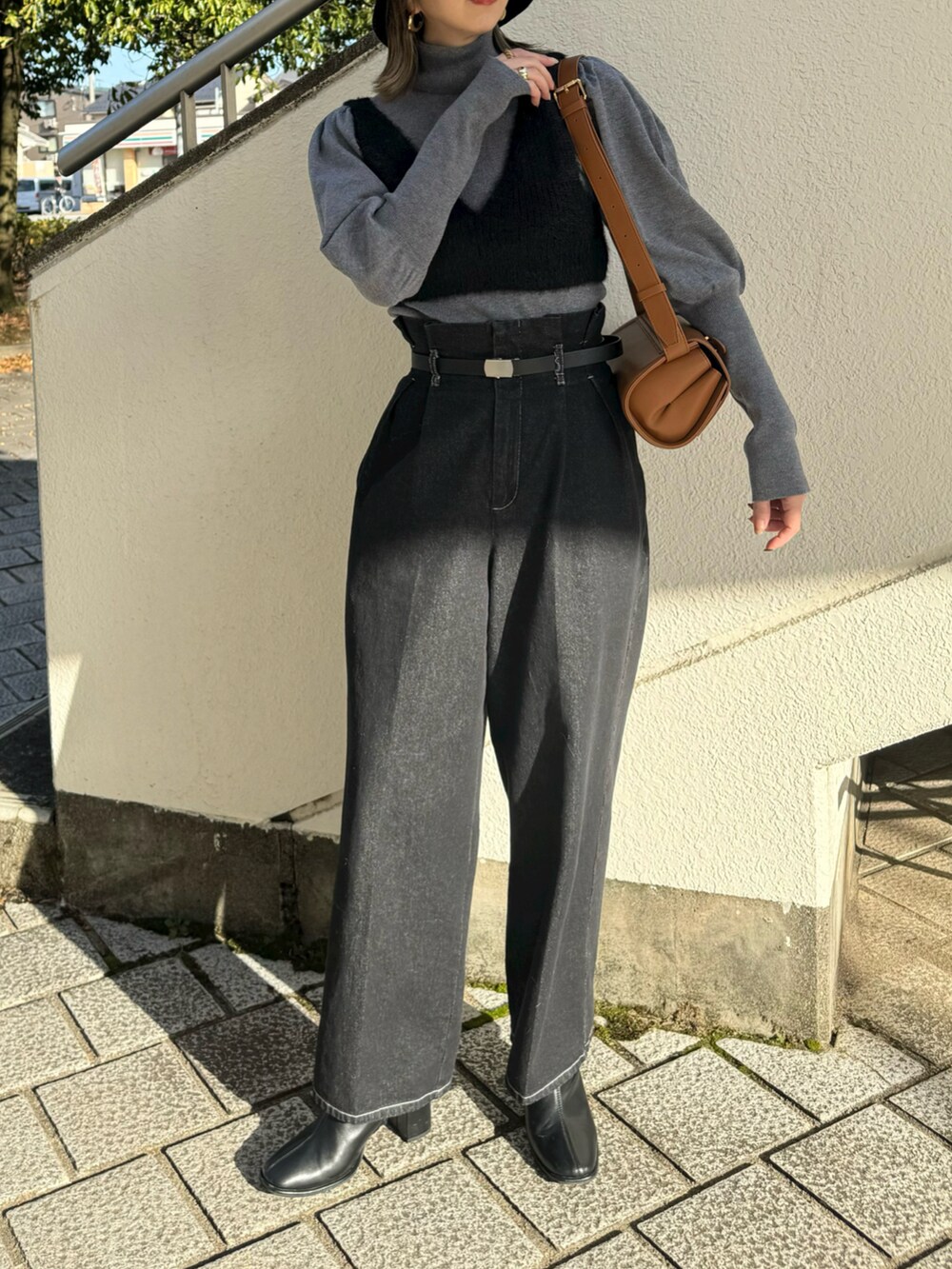 ブラック系のニット/セーター、ベージュ系のショルダーバッグ、グレー系のニット/セーターを着用したレディースの冬コーディネートの2枚目の写真