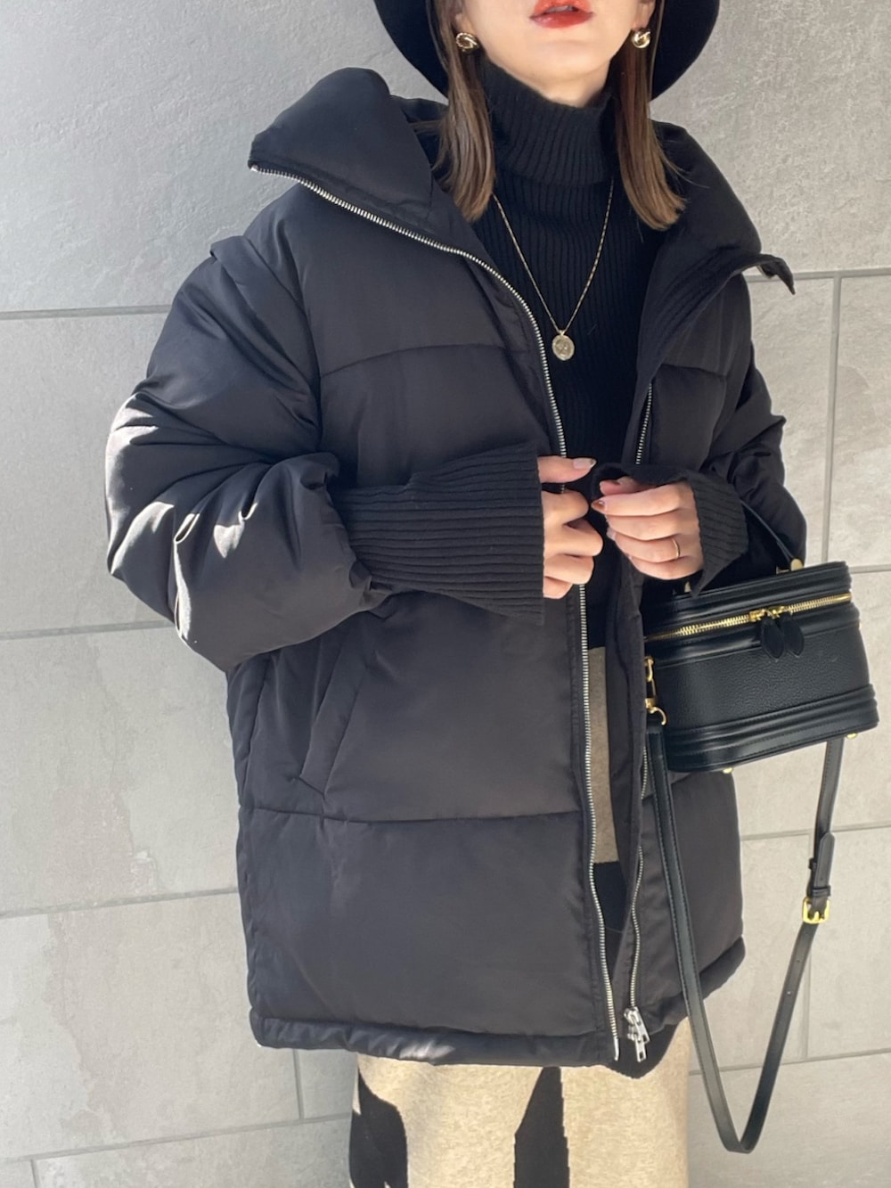 ブラック系のダウンジャケット/コート、ブラック系のブーツ、ブラック系のニット/セーターを着用したレディースの秋コーディネートの5枚目の写真