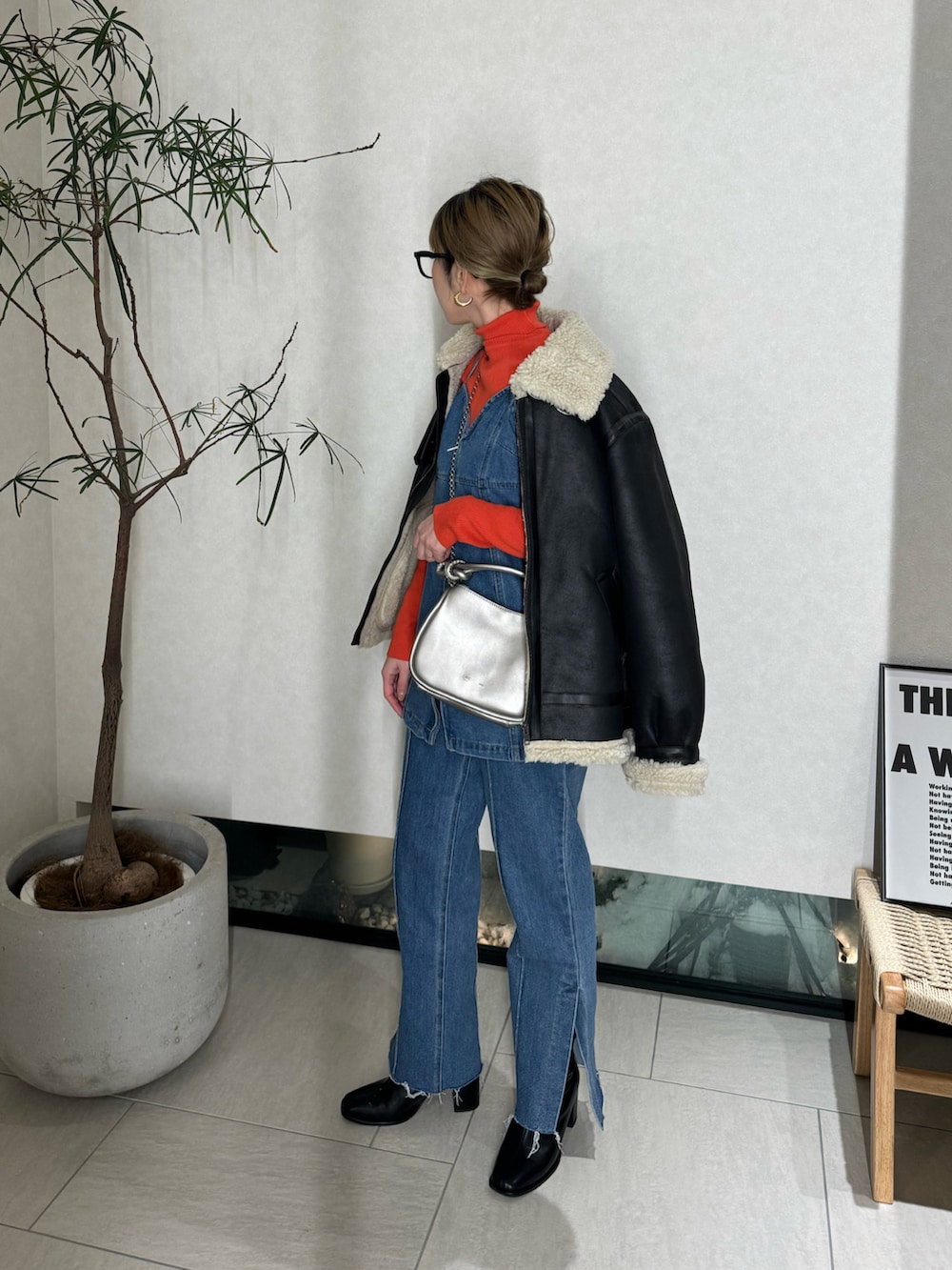 ブルー系のベスト、ブルー系のデニムパンツ、シルバー系のショルダーバッグを着用したレディースの冬コーディネートの3枚目の写真