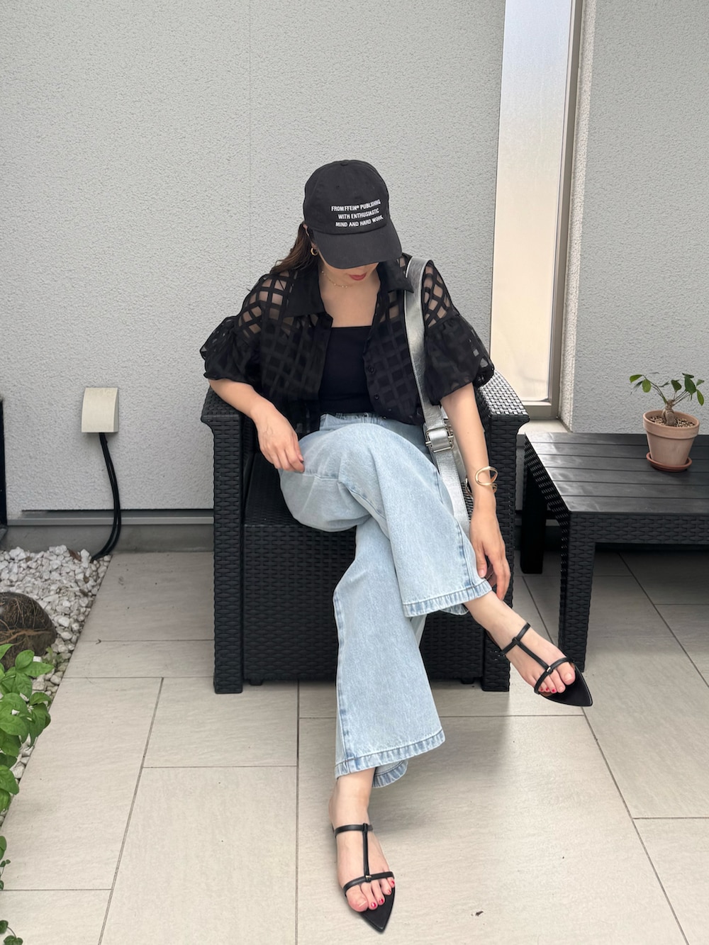 ブラック系のキャミソール、ブラック系のサンダル、ブルー系のデニムパンツを着用したレディースの夏コーディネートの5枚目の写真