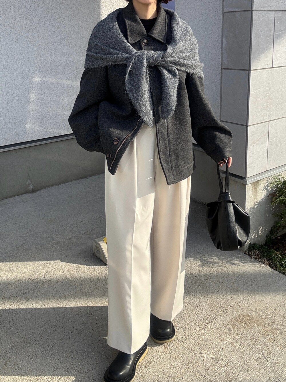 グレー系のその他アウター、ホワイト系のその他パンツ、ブラック系のハンドバッグを着用したレディースの冬コーディネートの2枚目の写真