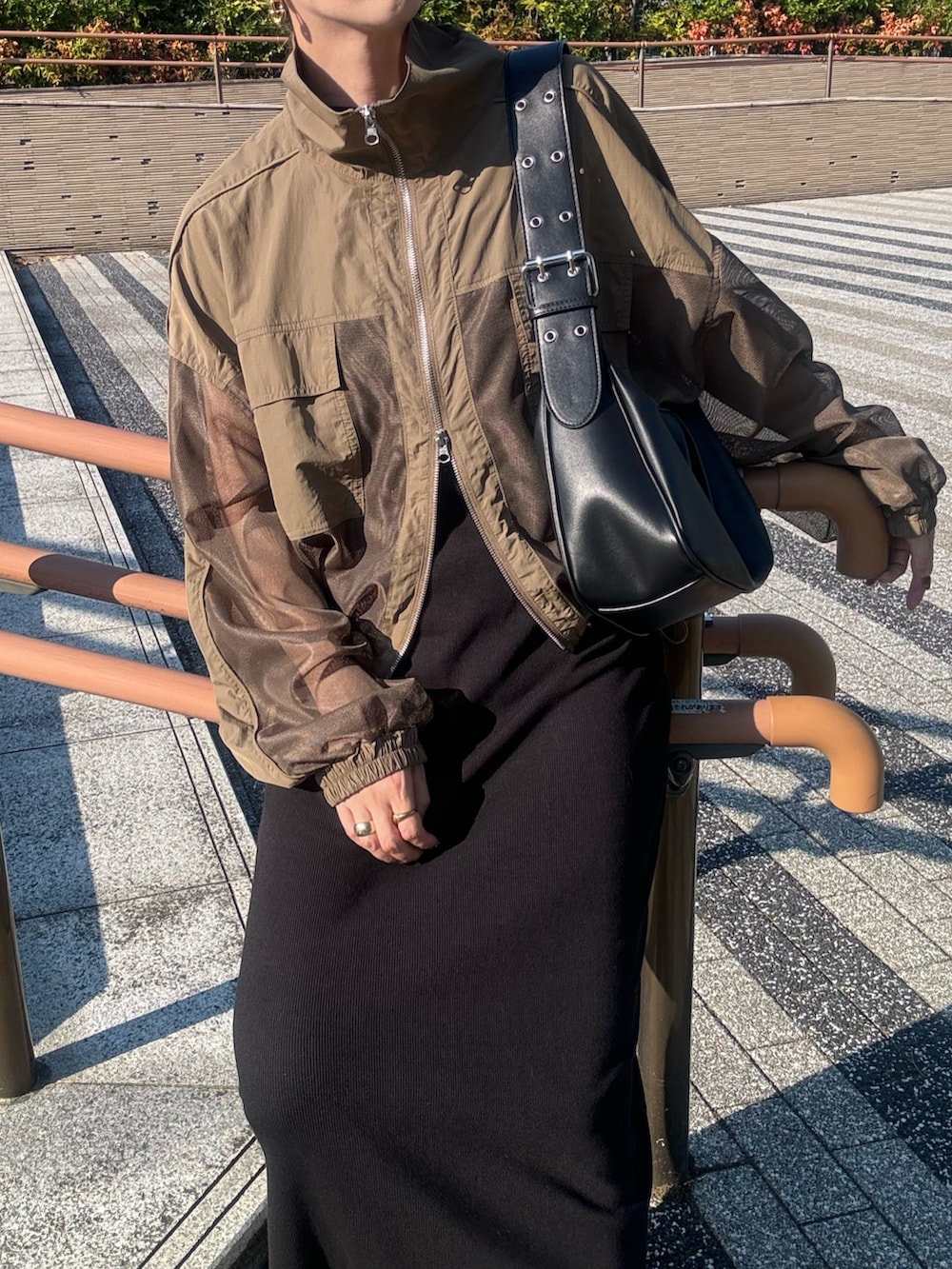 レッド系のスニーカー、ブラック系のハンドバッグ、ブラック系のワンピースを着用したレディースの秋コーディネートの5枚目の写真