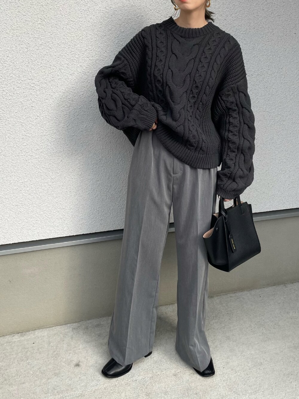 ブラック系のニット/セーター、ブラック系のハンドバッグを着用したレディースの秋コーディネートの3枚目の写真