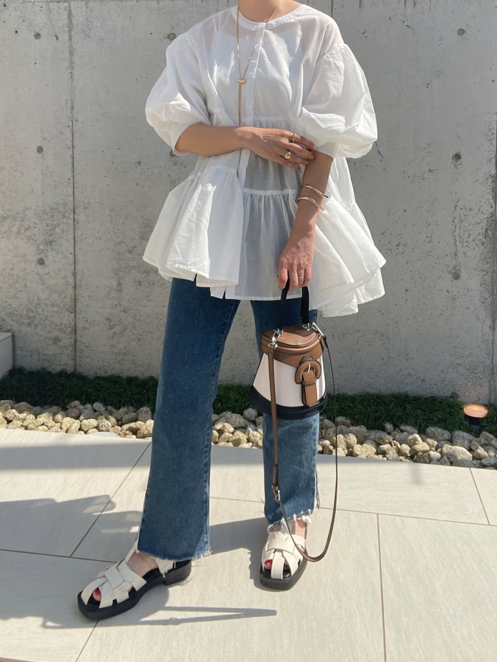 ホワイト系のシャツ/ブラウス、ブルー系のデニムパンツ、ホワイト系のサンダルを着用したレディースの夏コーディネートの2枚目の写真