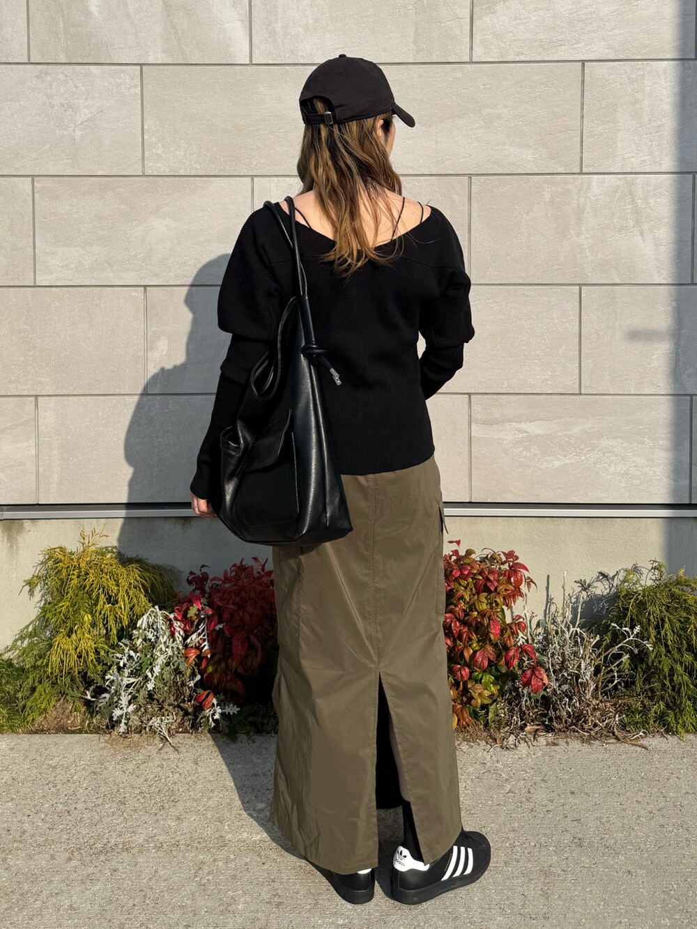 ブラック系のカーディガン/ボレロ、グリーン系のスカート、ブラック系のショルダーバッグを着用したレディースの春コーディネートの4枚目の写真