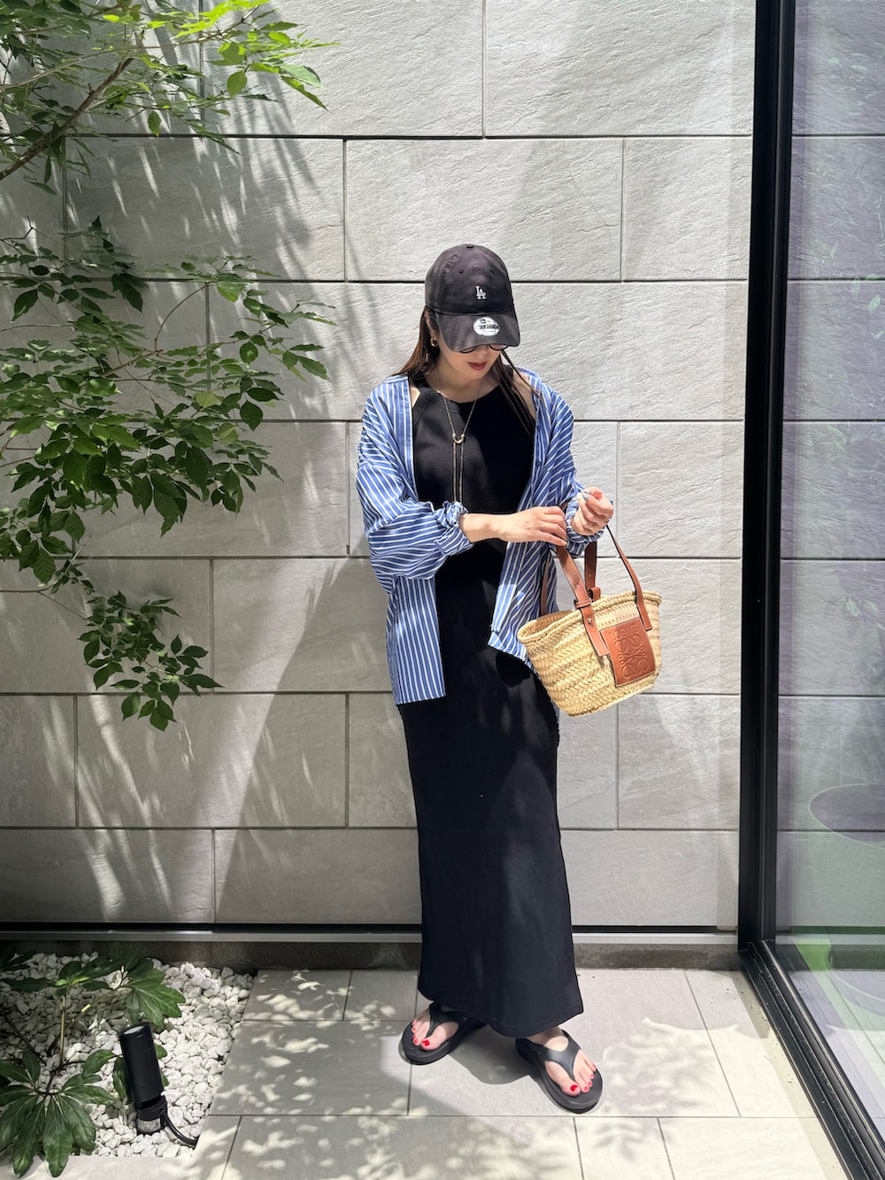 ブルー系のシャツ/ブラウス、ブラック系のワンピース、ブラウン系のトートバッグを着用したレディースの夏コーディネートの2枚目の写真