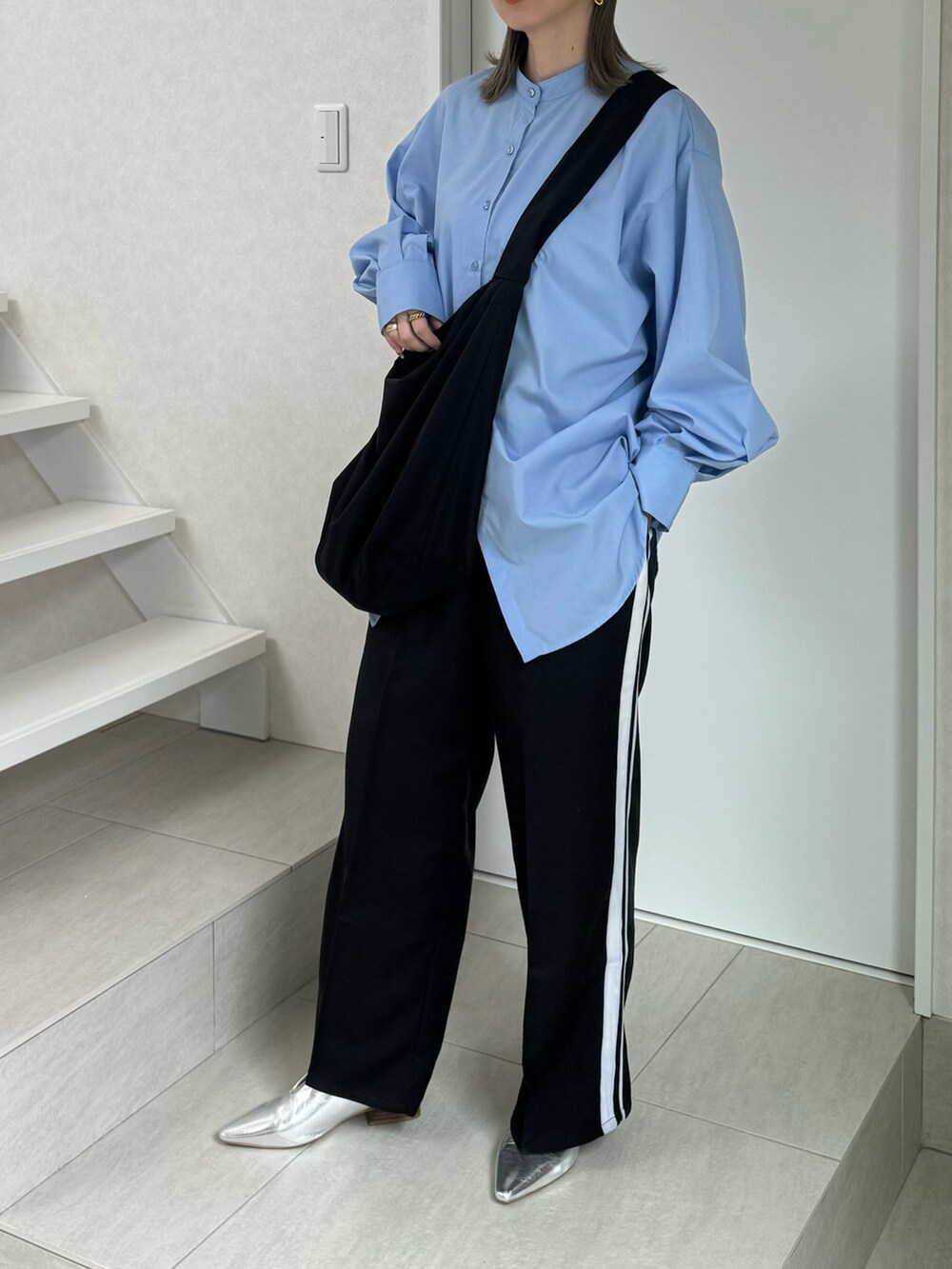 ブルー系のシャツ/ブラウス、ブラック系のスラックス、シルバー系のパンプスを着用したレディースの冬コーディネートの4枚目の写真