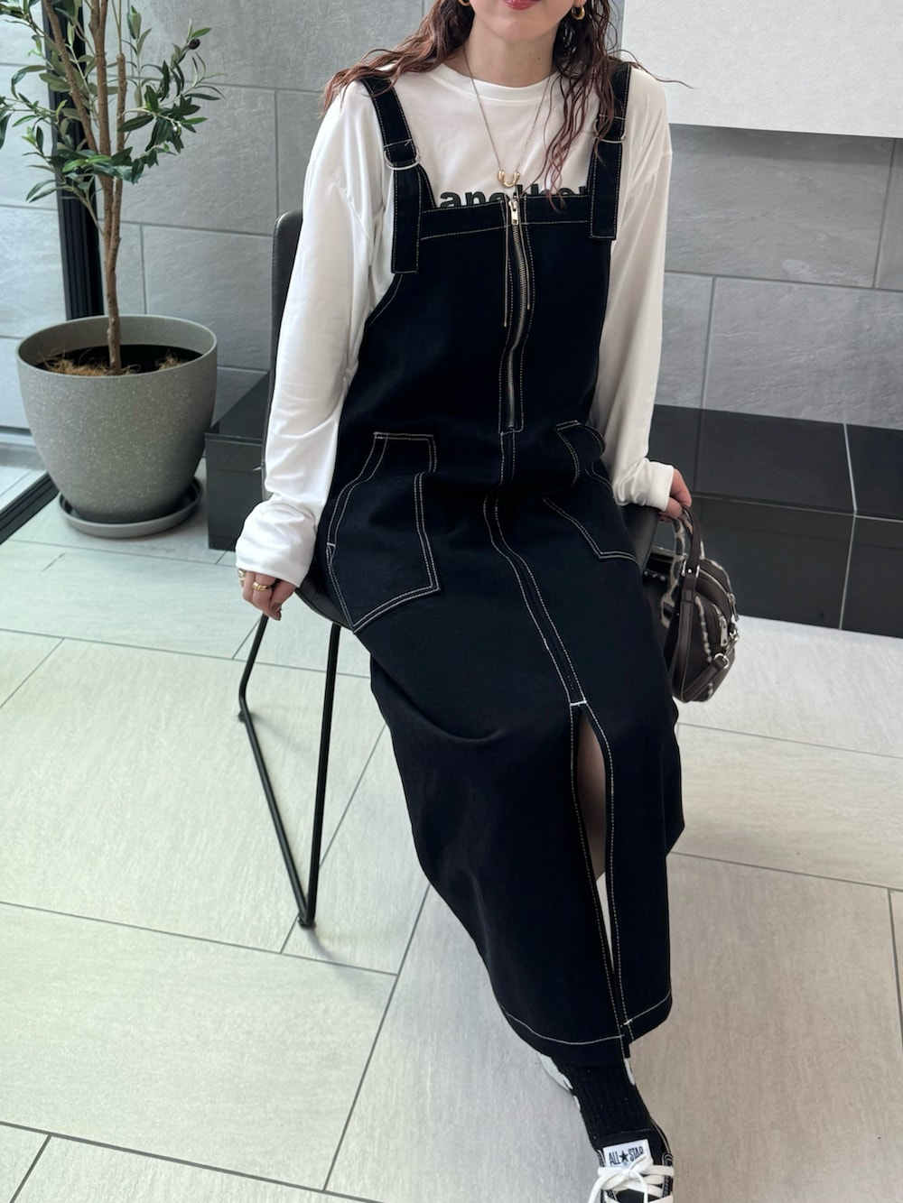 ホワイト系のTシャツ/カットソー、ブラウン系のキャップを着用したレディースの秋コーディネートの2枚目の写真