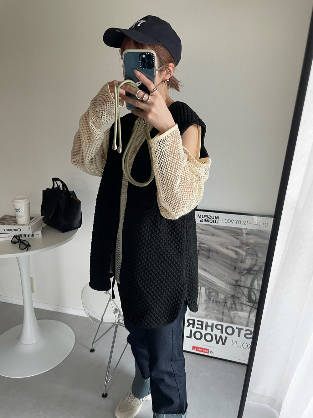 ブラック系のベスト、ブルー系のデニムパンツ、ホワイト系のTシャツ/カットソーを着用したレディースの春コーディネートの3枚目の写真