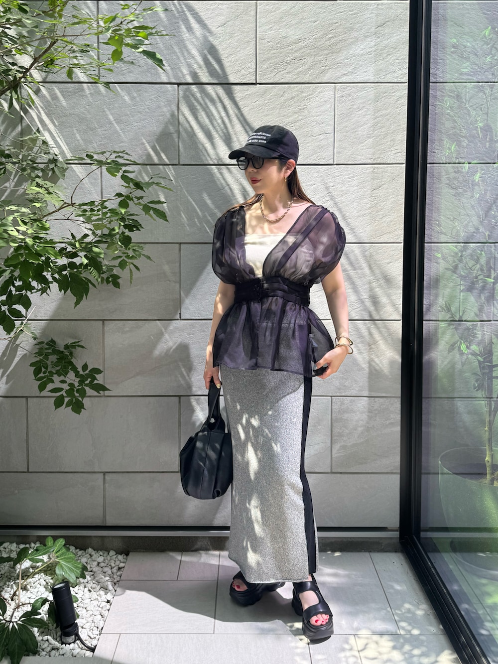 ブラック系のTシャツ/カットソー、ブラック系のサンダル、ブラック系のハンドバッグを着用したレディースの夏コーディネートの2枚目の写真